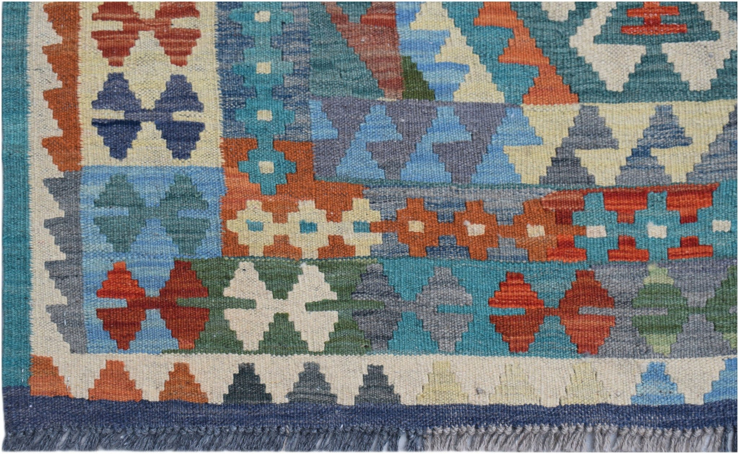 Handwoven Afghan Maimana kilim rug featuring a colorful geometric pattern and fringed edges.