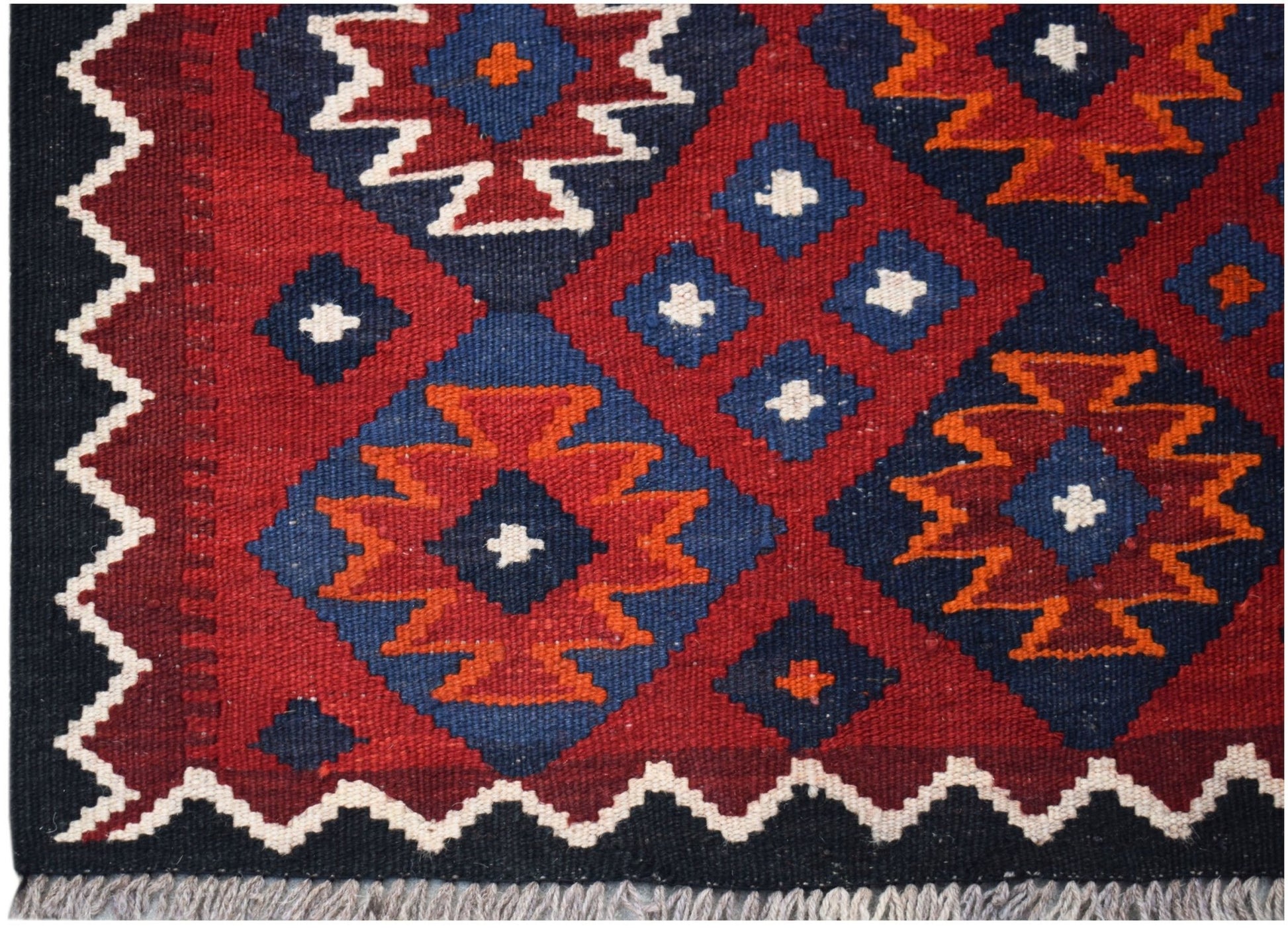 Handwoven Afghan Maimana kilim featuring a geometric pattern in red, blue, and orange wool.