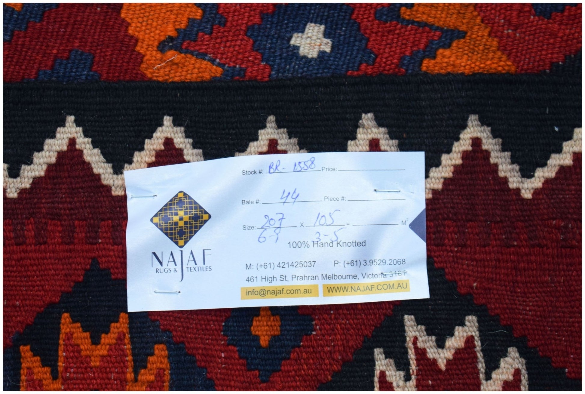 A flatwoven Afghan Maimana Kilim featuring a geometric pattern in red, orange, and dark blue.