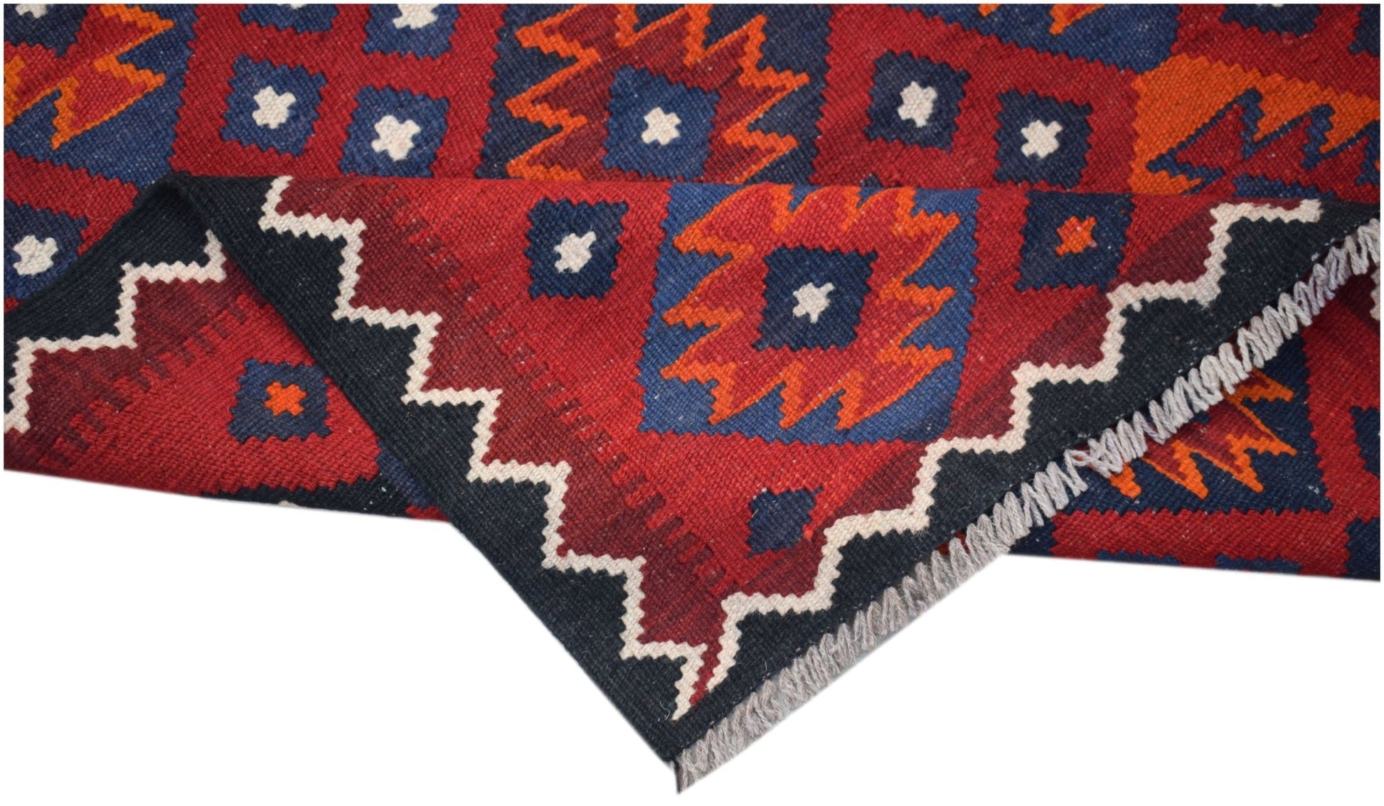 A handmade Afghan Maimana kilim featuring a geometric pattern in red, blue, and orange wool.