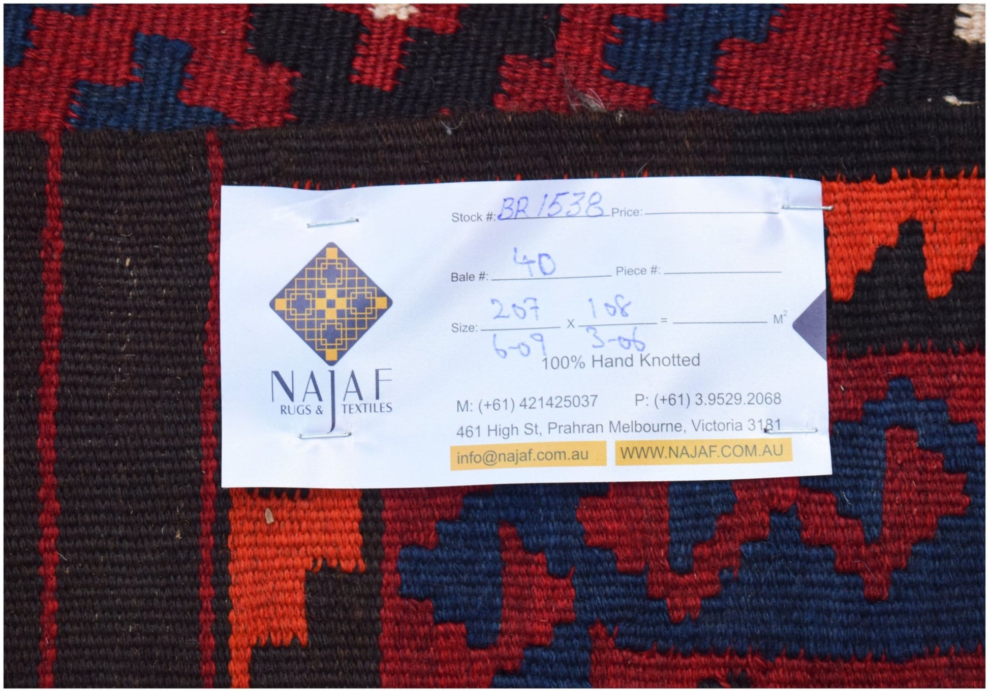 A handmade Afghan Maimana kilim featuring a geometric pattern in red, blue, and dark brown wool.