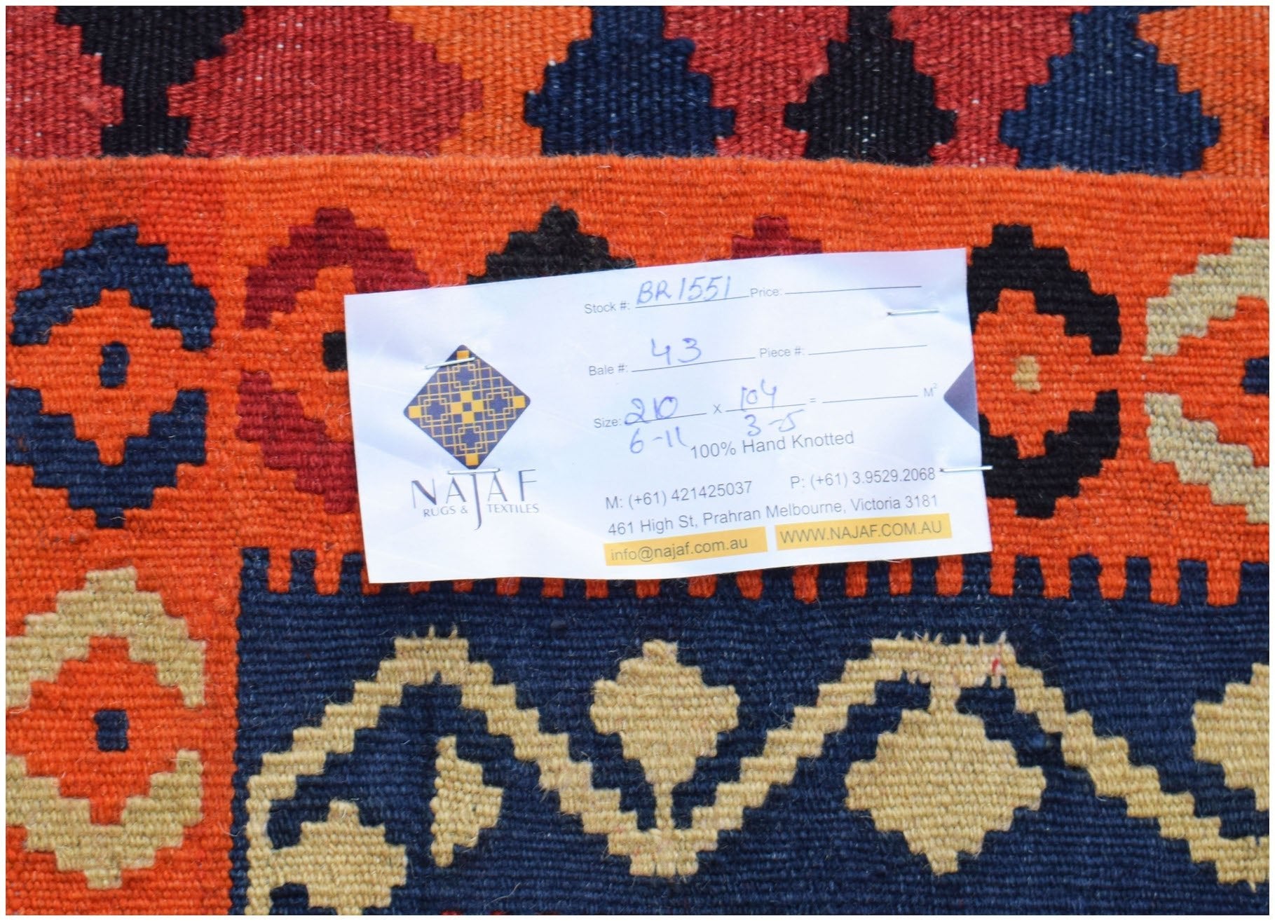 Handwoven Afghan Maimana kilim featuring a geometric pattern in orange, navy blue, and beige.