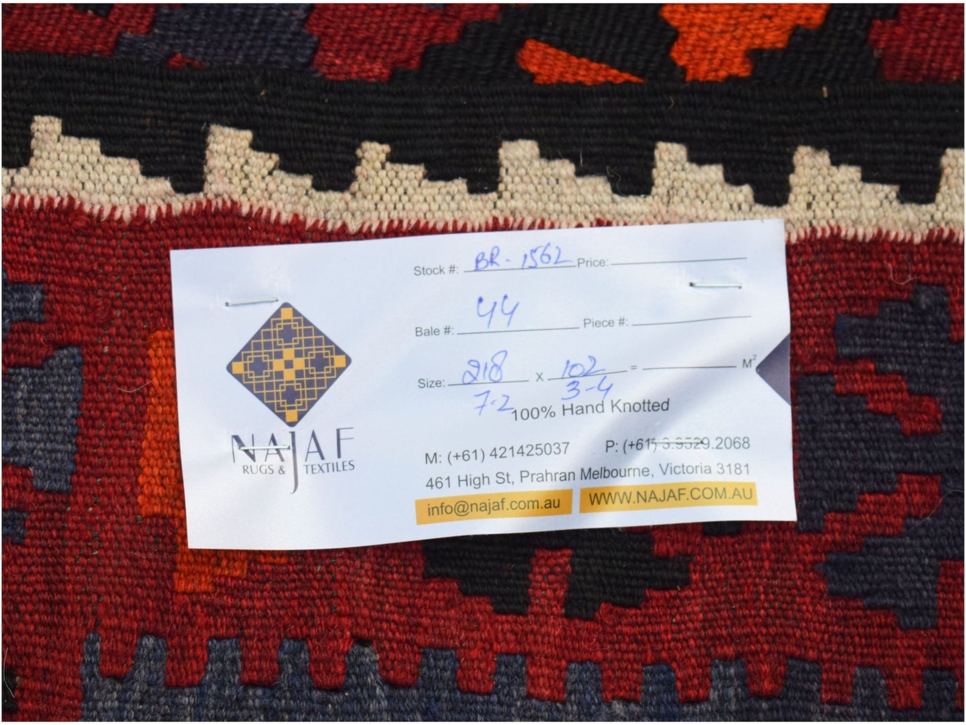 A handwoven Afghan Maimana kilim featuring a geometric pattern in red, black, and orange tones.
