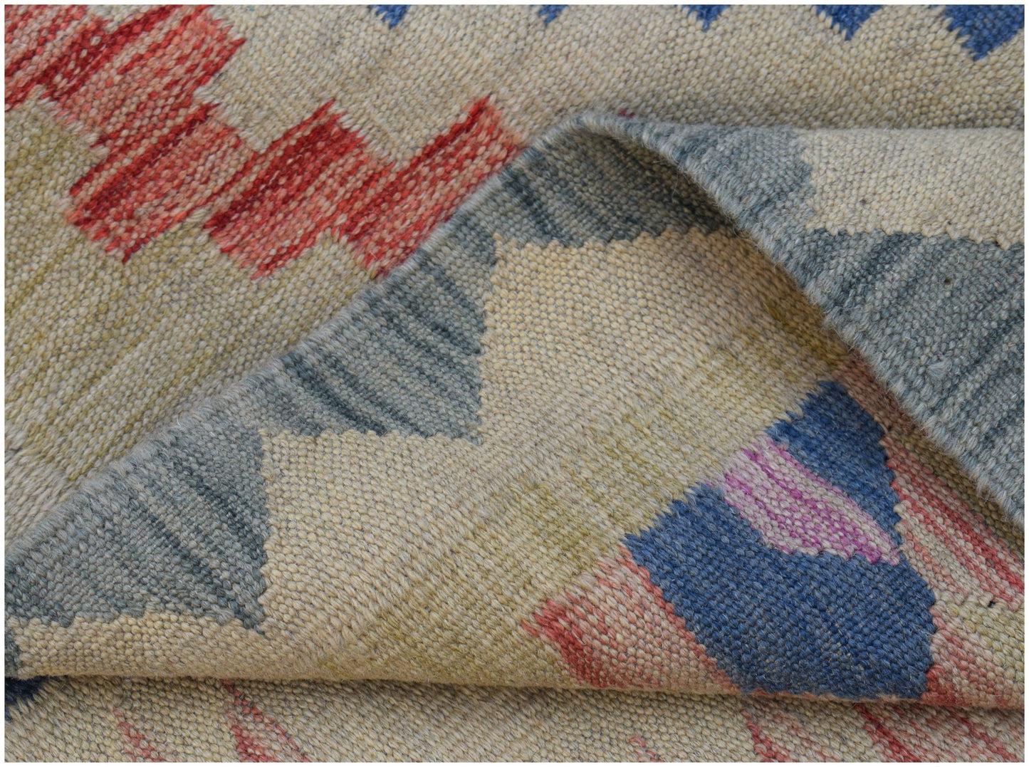 A close-up view of a handwoven Afghan Maimana kilim featuring geometric patterns in wool.