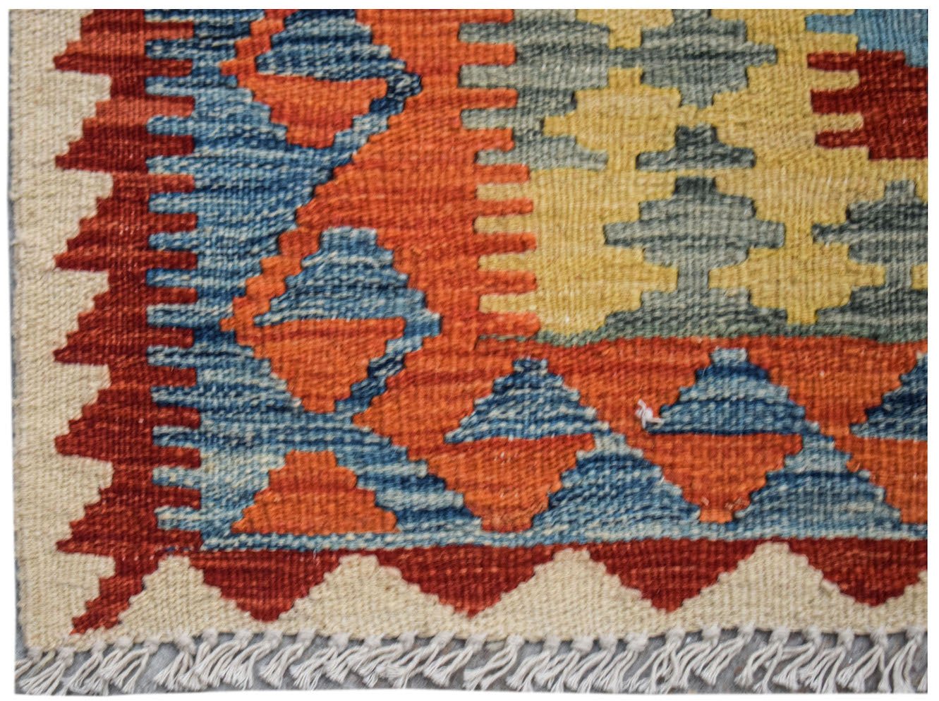 Handwoven Afghan Maimana kilim featuring a geometric pattern in blue, orange, and yellow.