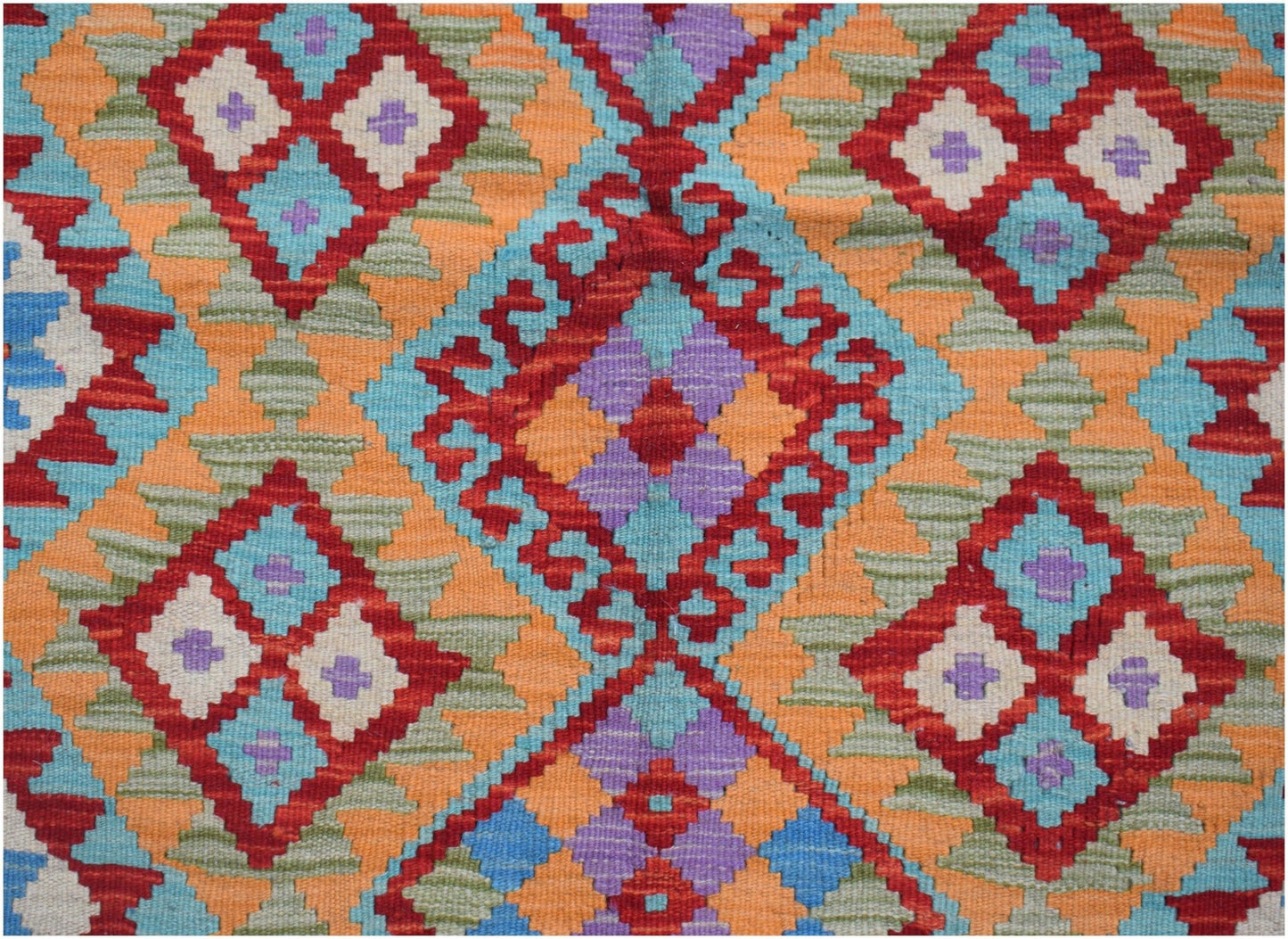 Handwoven Afghan Maimana kilim featuring a geometric diamond pattern in red, blue, and orange.