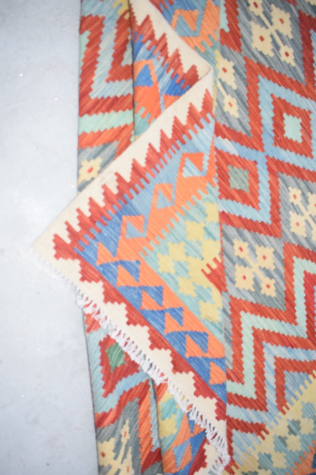 Afghan Maimana Kilim with geometric patterns in red, blue, orange, and yellow.