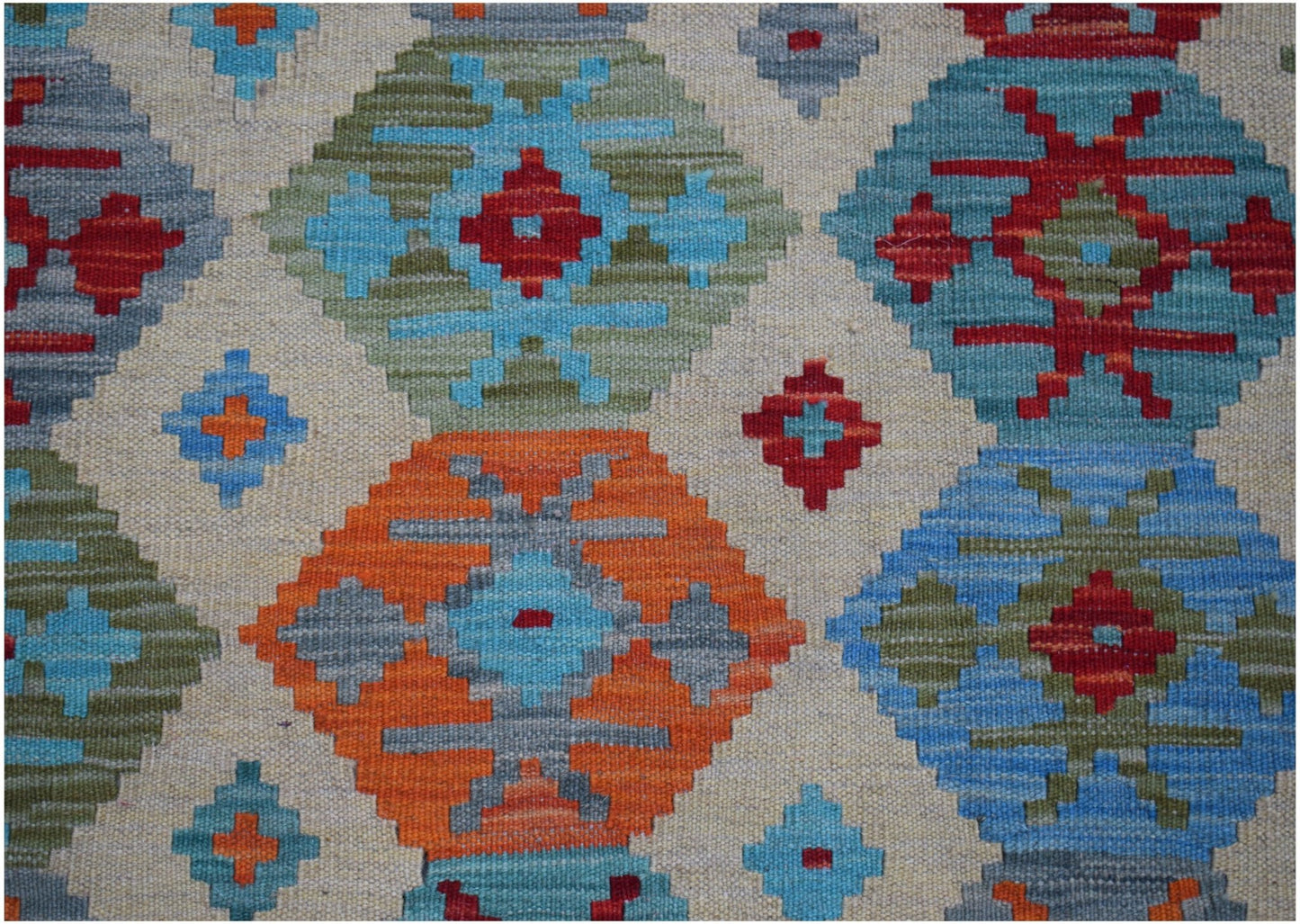 Handwoven Afghan Maimana kilim rug featuring a geometric pattern in vibrant blue, orange, and red.