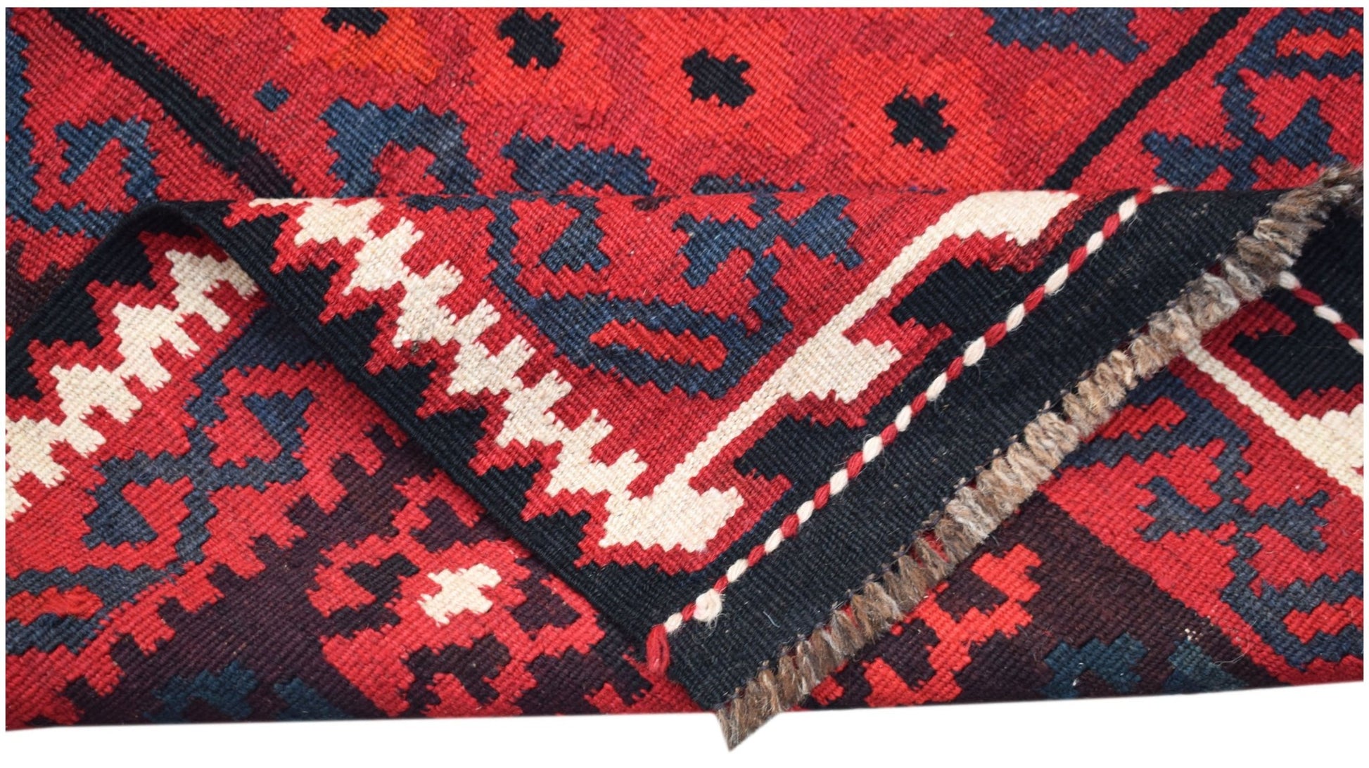 A handwoven Afghan Maimana kilim featuring a geometric pattern in red, black, and cream wool.