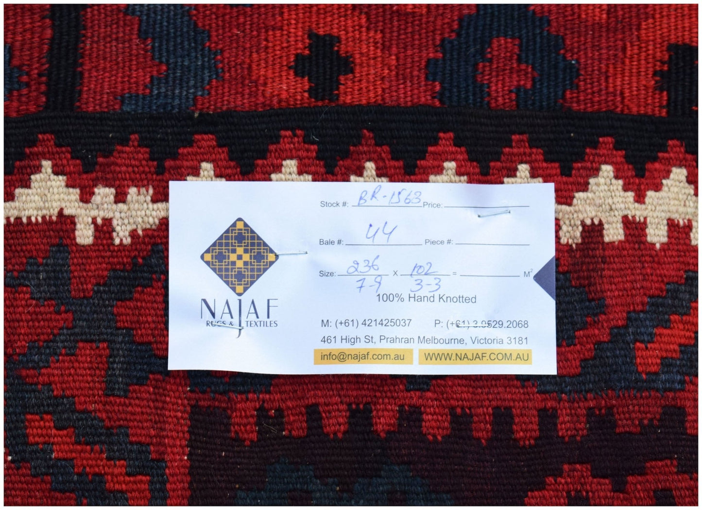 A handwoven Afghan Maimana Kilim featuring a geometric pattern in shades of red, black, and cream.