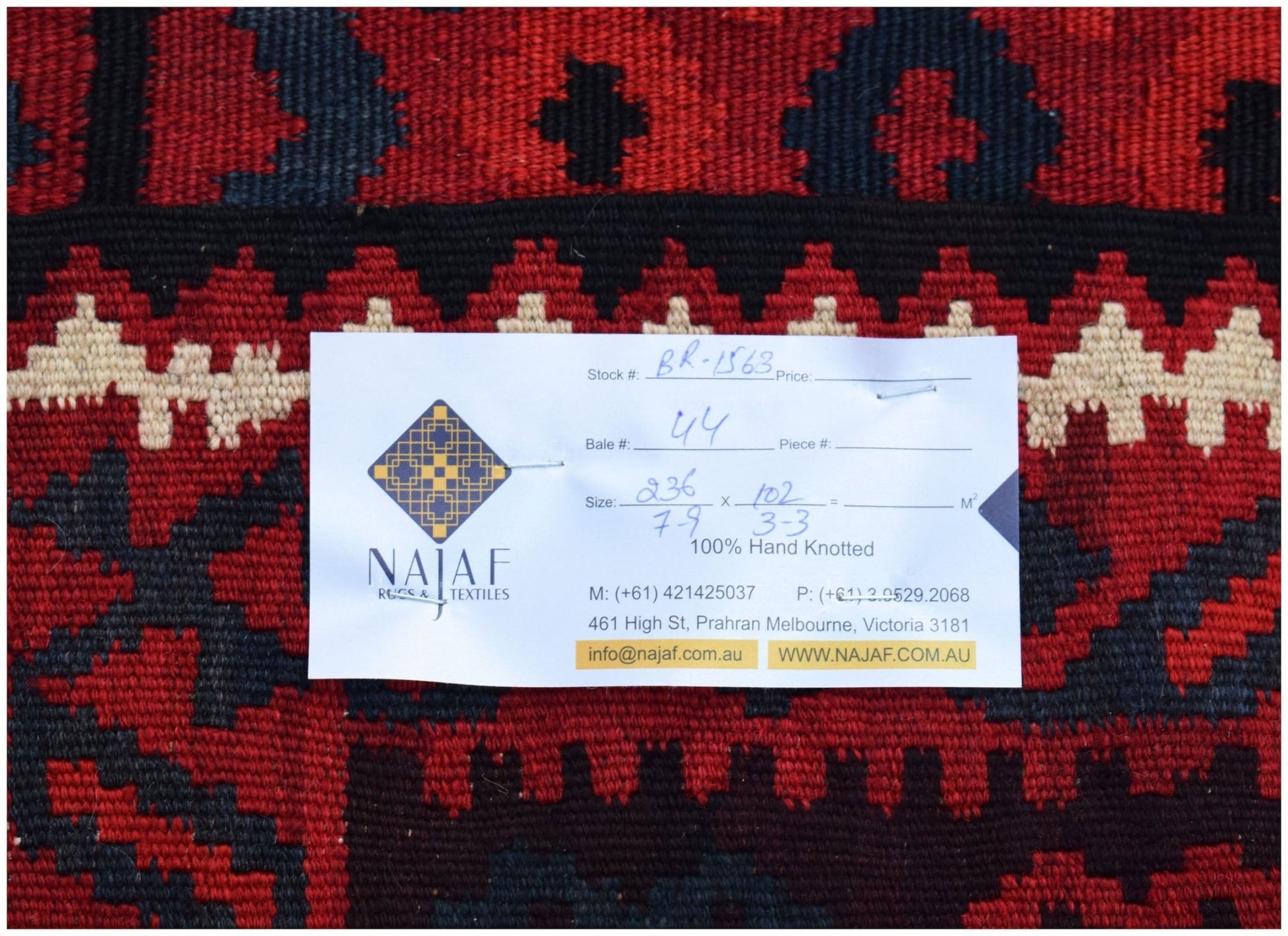 A handwoven Afghan Maimana Kilim featuring a geometric pattern in shades of red, black, and cream.