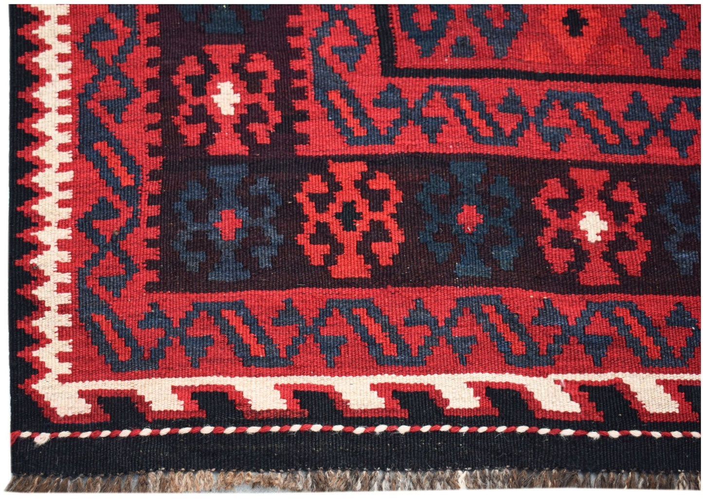 Handwoven Afghan Maimana kilim featuring geometric patterns in red, black, and white wool.