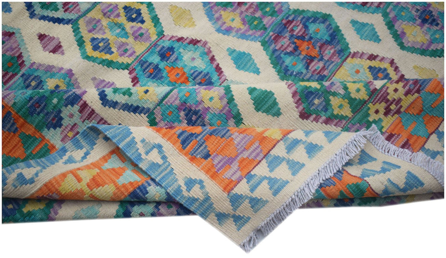 A handmade Afghan Maimana kilim rug featuring a colorful geometric pattern on a cream background.