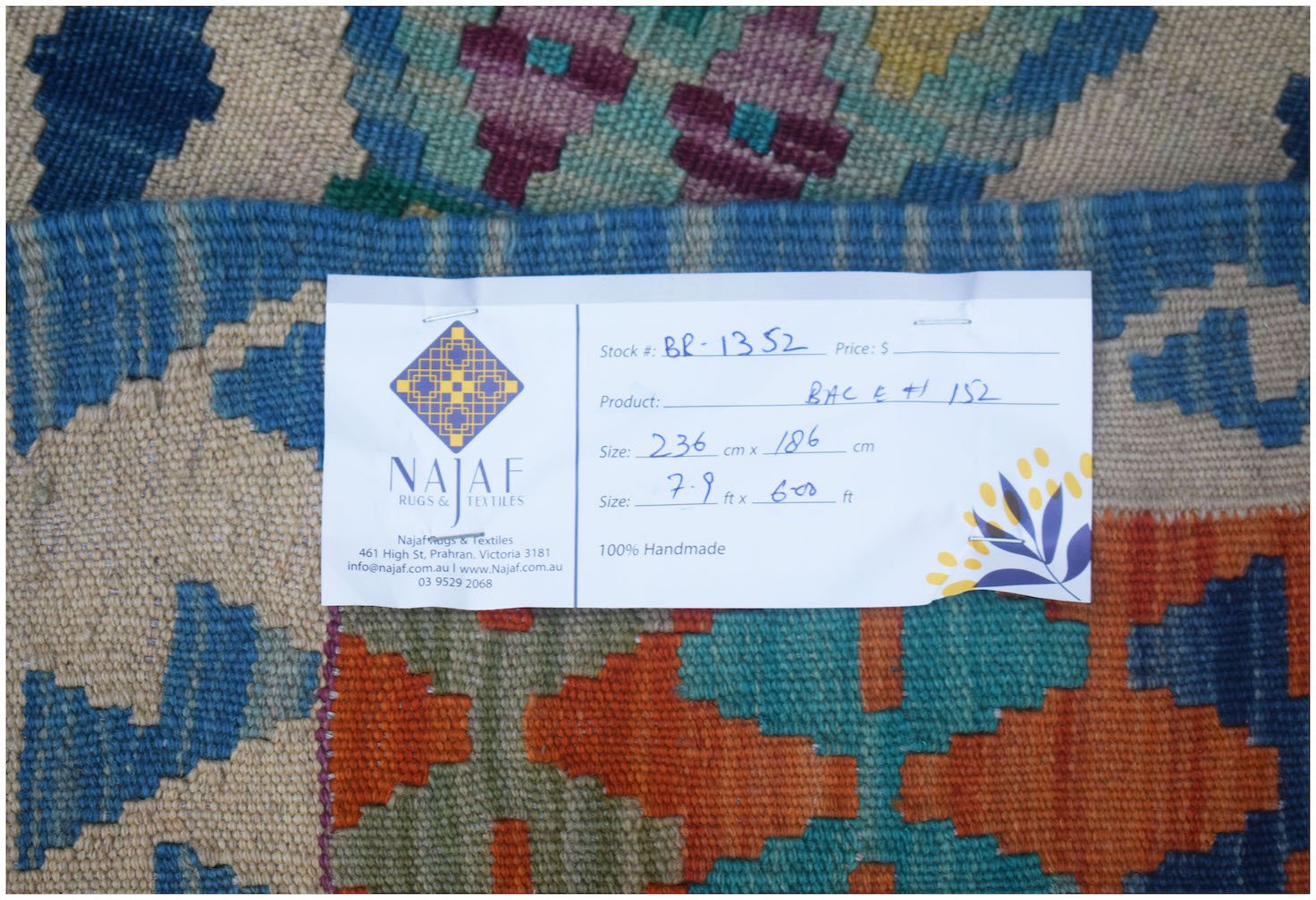 A handmade Afghan Maimana Kilim rug featuring a geometric pattern in blue, orange, and cream.