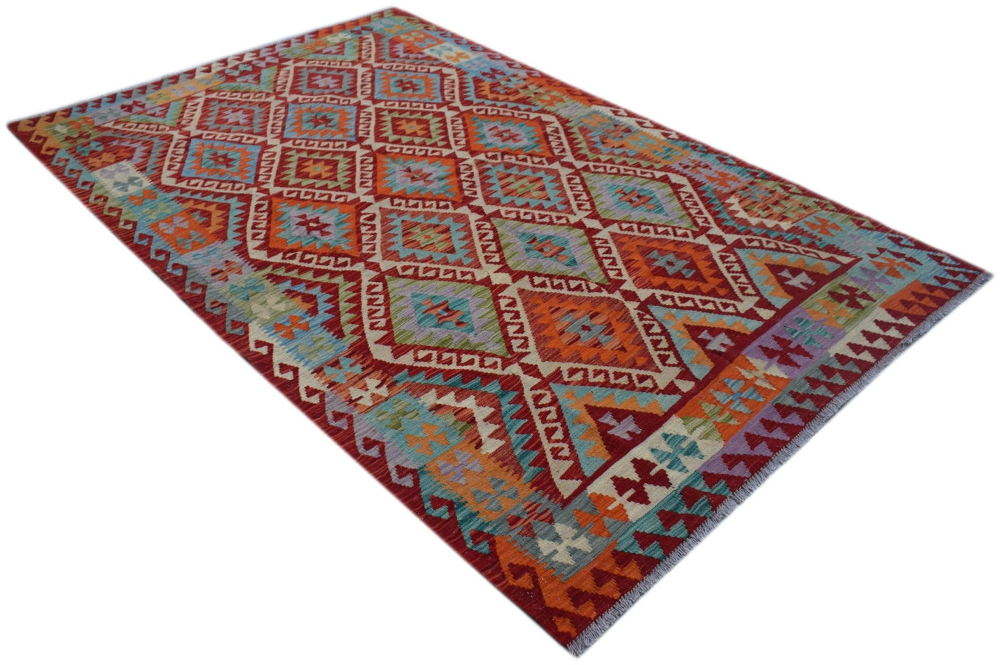 Handwoven Afghan Maimana kilim rug featuring a vibrant geometric diamond pattern in wool.