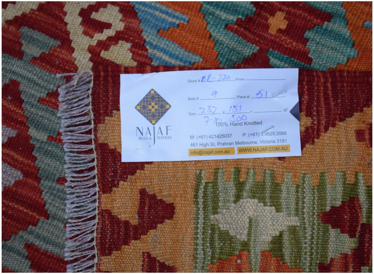 A flatwoven Afghan Maimana Kilim featuring a geometric pattern in shades of red, orange, and green.