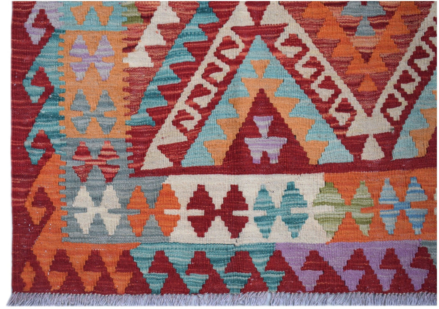 Handwoven Afghan Maimana kilim rug featuring a vibrant geometric pattern in wool.