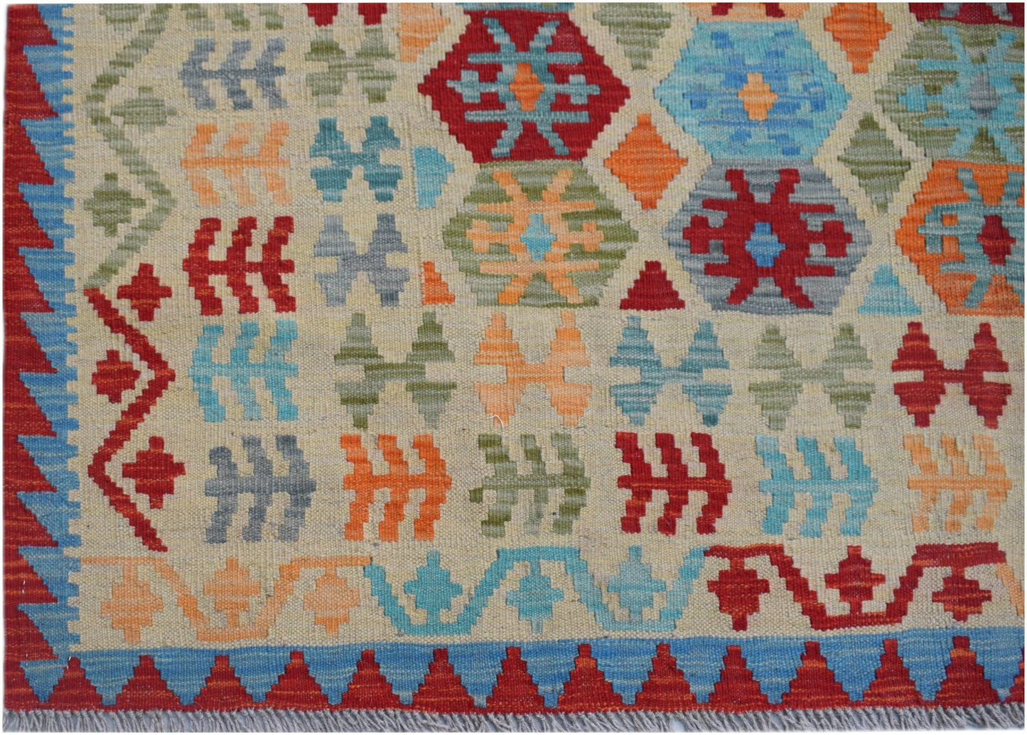 Handwoven Afghan Maimana kilim featuring a colorful geometric pattern on a cream background.