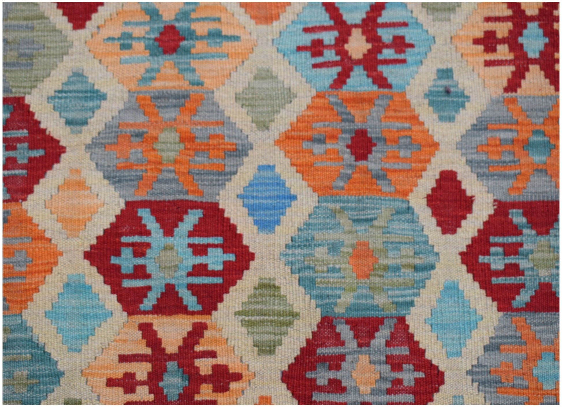 Handwoven Afghan Maimana kilim rug featuring a colorful geometric diamond pattern in wool.