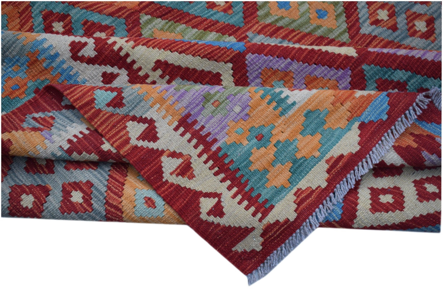 A handwoven Afghan Maimana kilim rug featuring a vibrant geometric pattern in wool.