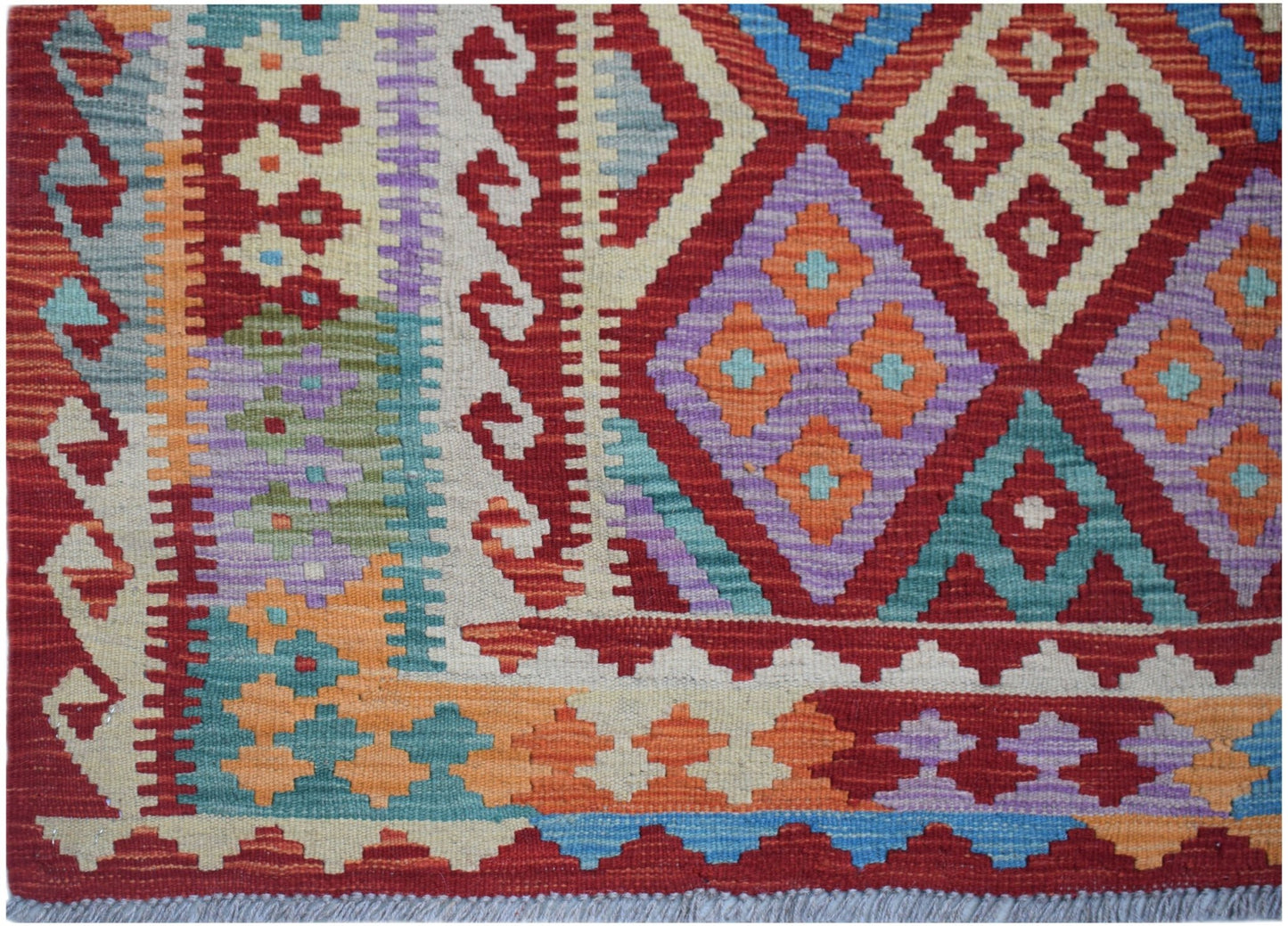 Handwoven Afghan Maimana kilim featuring a vibrant geometric pattern in wool.
