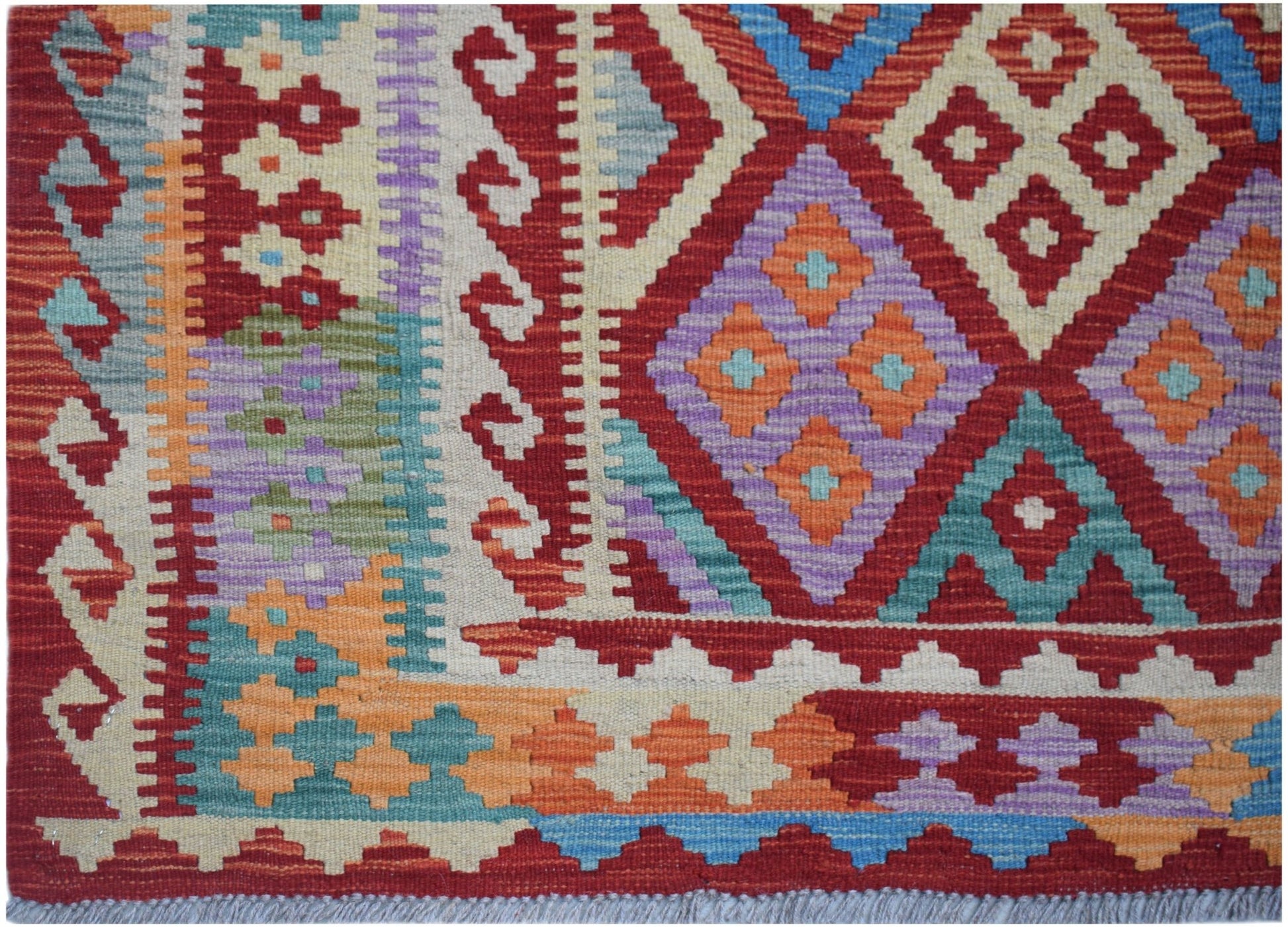 Handwoven Afghan Maimana kilim featuring a vibrant geometric pattern in wool.