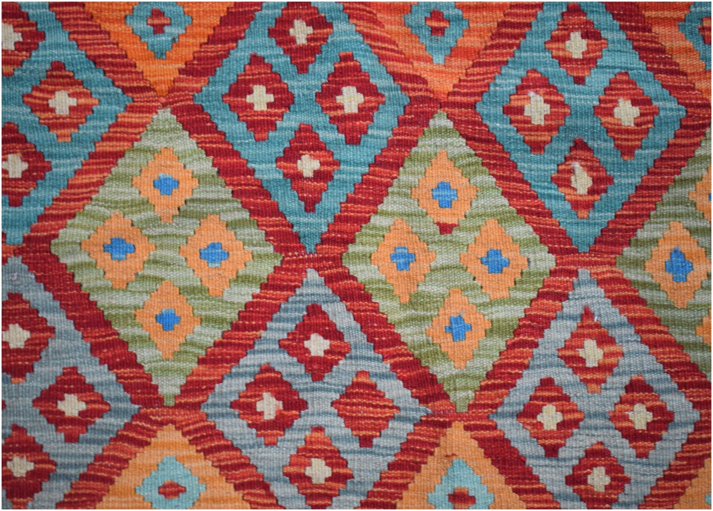 Handwoven Afghan Maimana kilim featuring a vibrant geometric diamond pattern in wool.