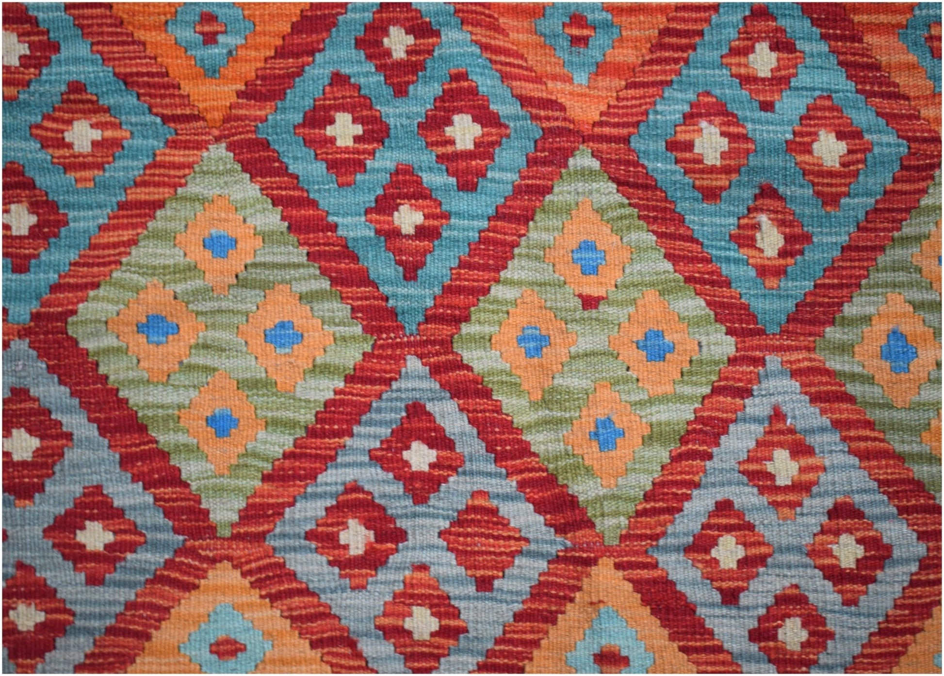 Handwoven Afghan Maimana kilim featuring a vibrant geometric diamond pattern in wool.