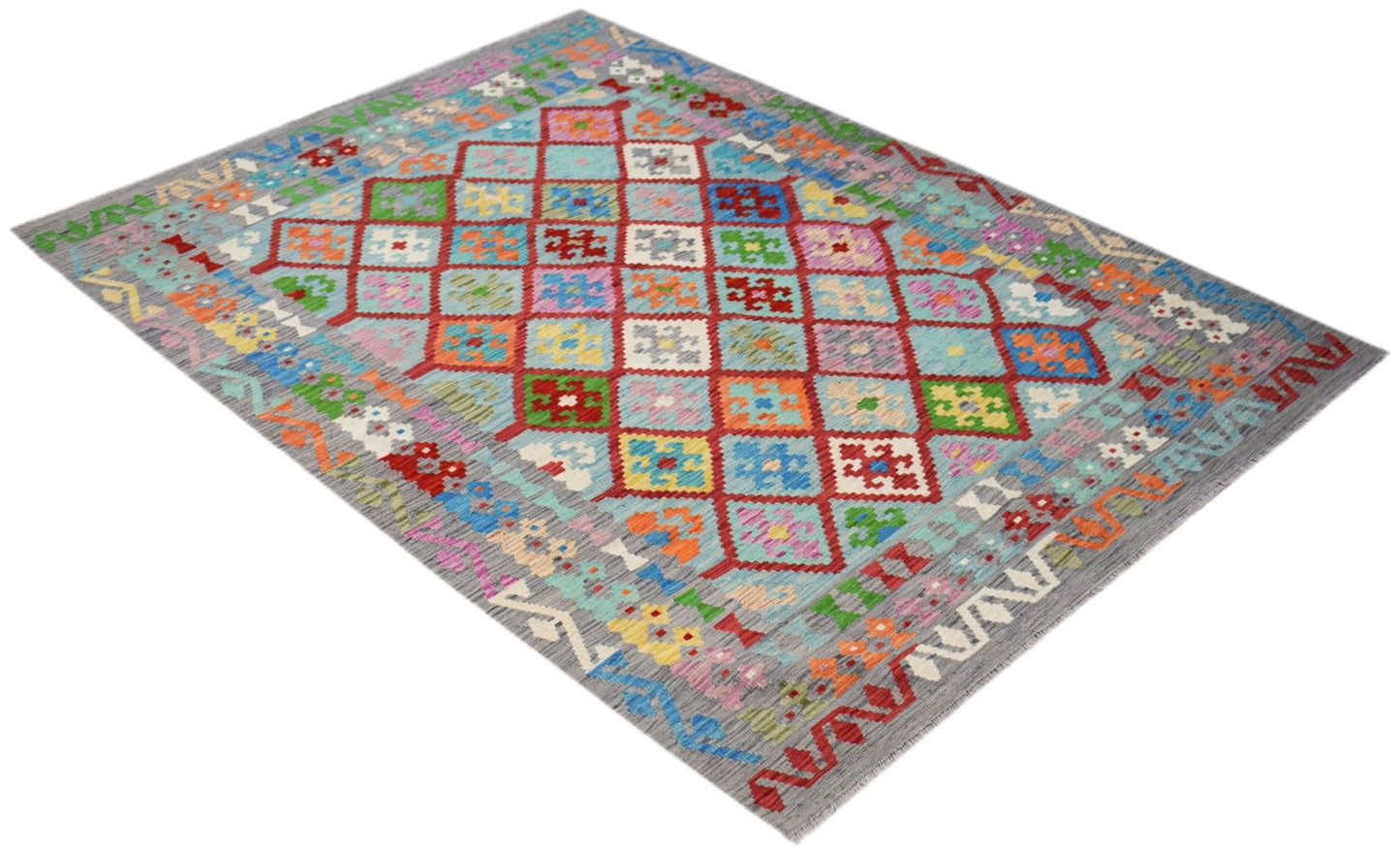 Handwoven Afghan Maimana Kilim rug featuring a colorful geometric diamond pattern on a grey base.