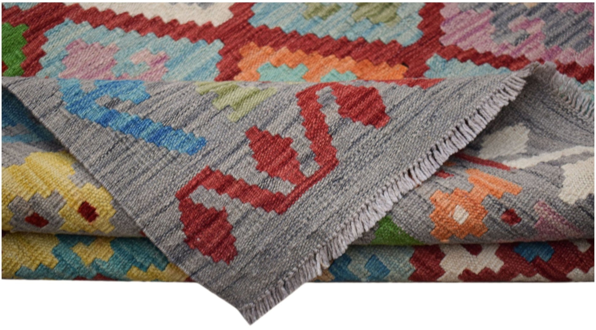 A handwoven Afghan Maimana kilim featuring a colorful geometric pattern and flatweave texture.