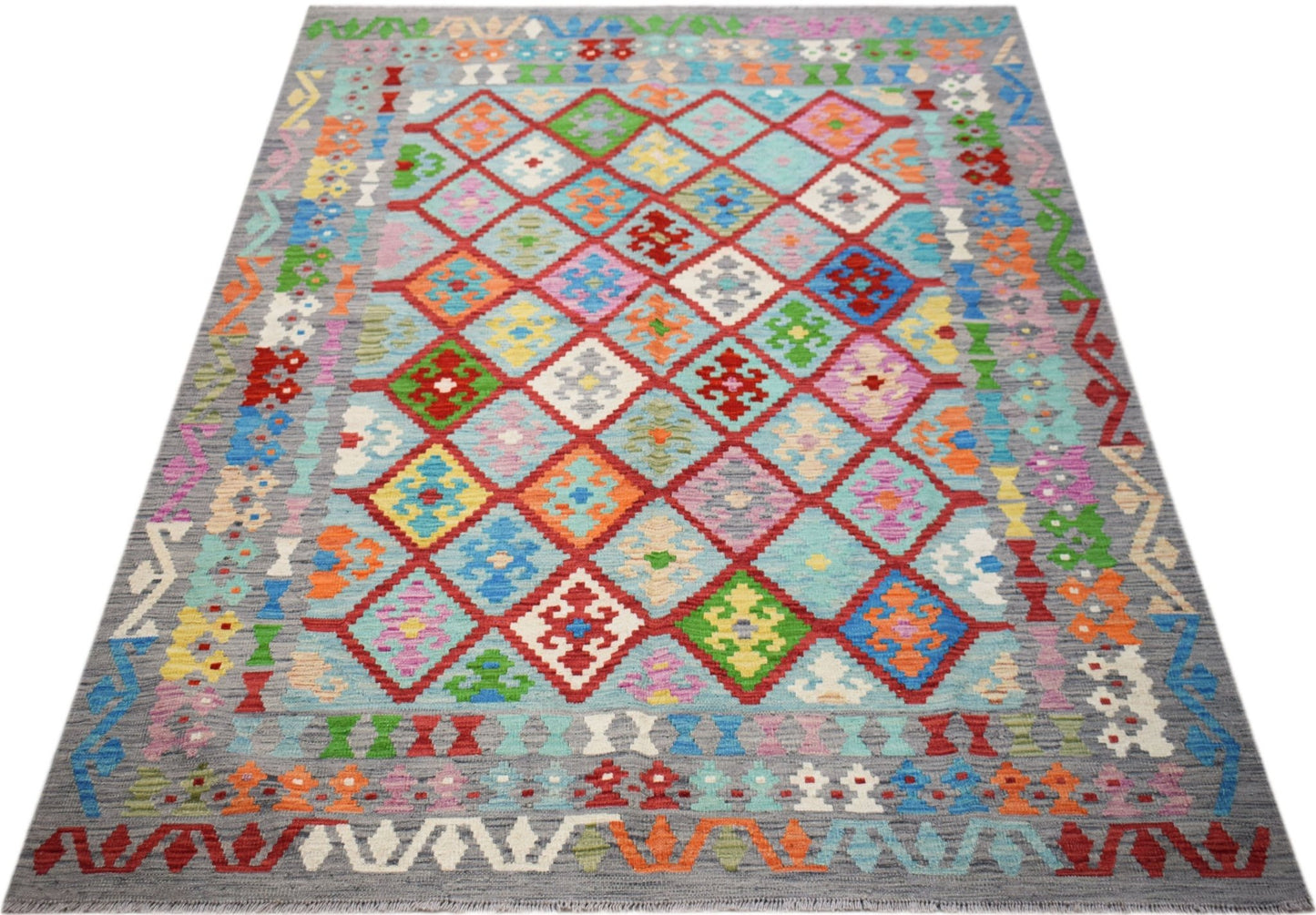 Handwoven Afghan Maimana kilim rug featuring a colorful geometric diamond pattern on a grey field.