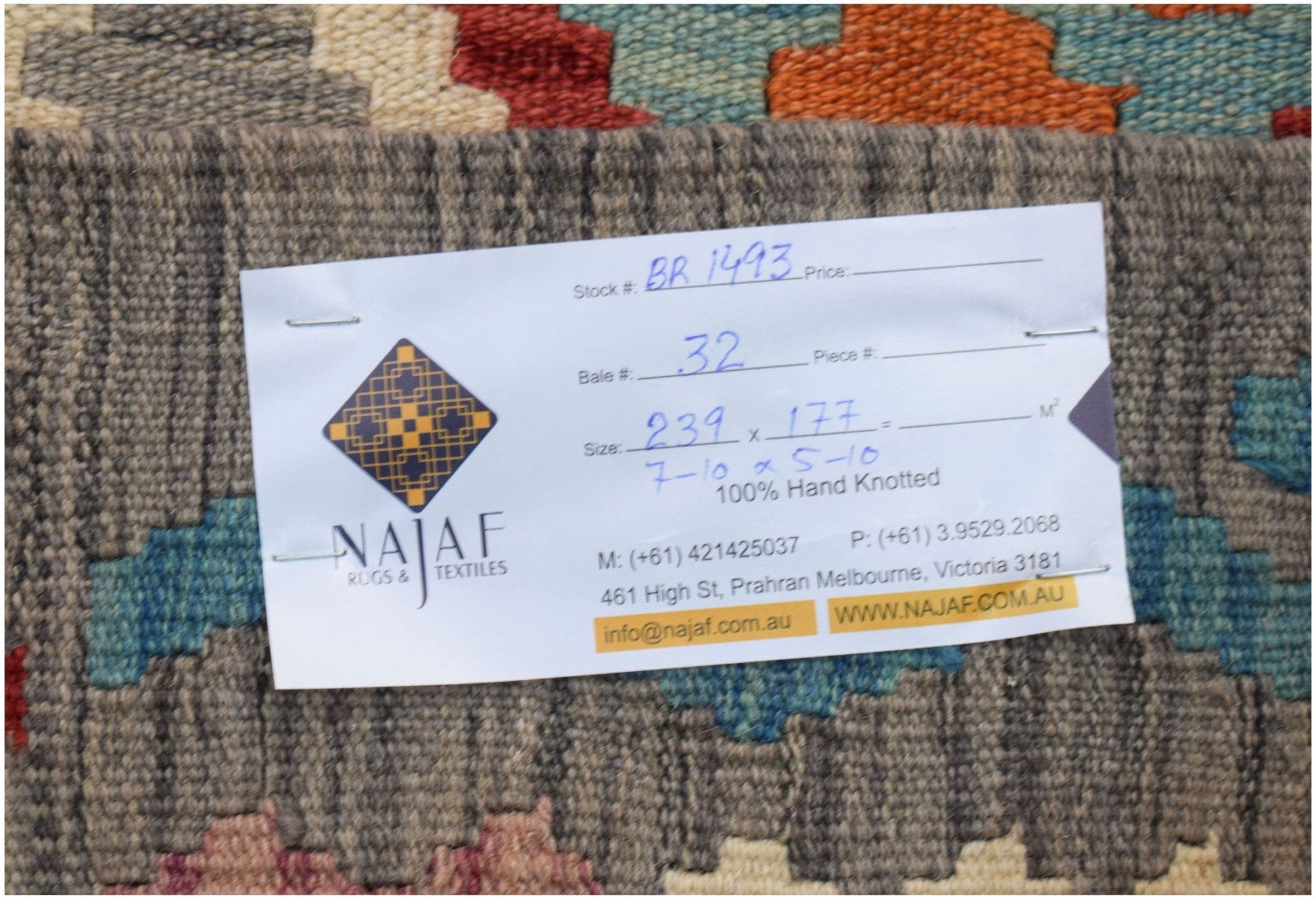 A handwoven Afghan Maimana kilim featuring a geometric pattern in vibrant, multi-colored wool.