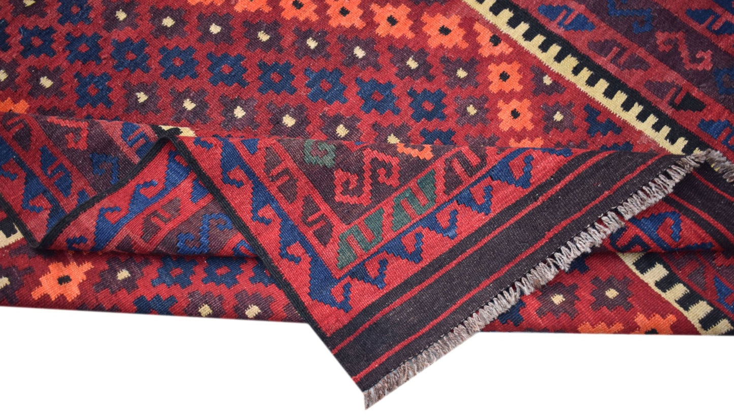 A handmade Afghan Maimana kilim featuring a geometric pattern in red, blue, and orange wool.