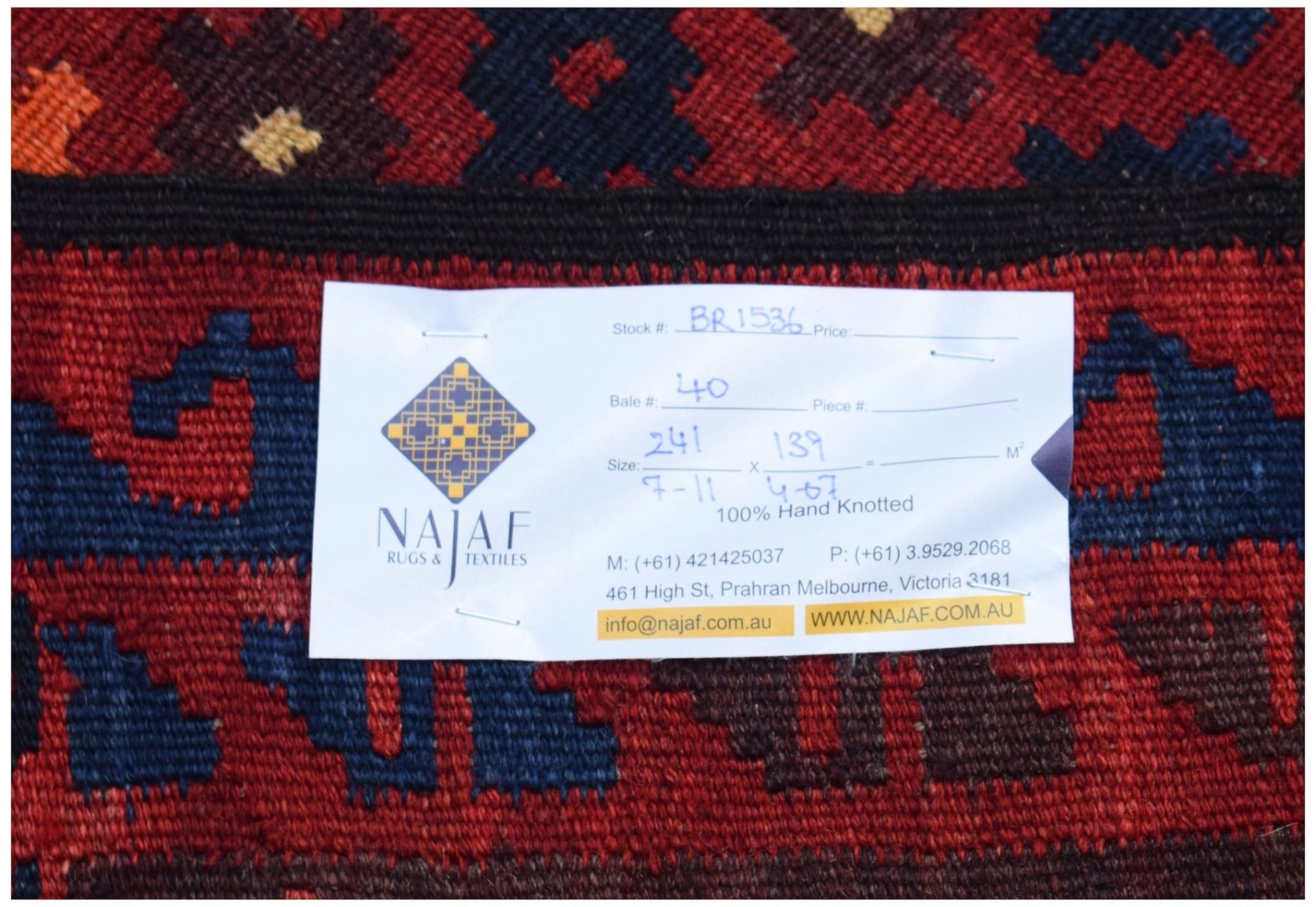 A close-up of a handwoven Afghan Maimana Kilim featuring geometric patterns in red and blue.