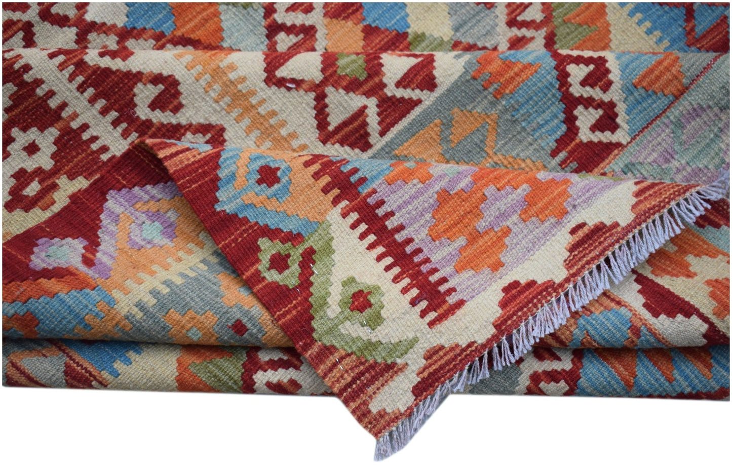 A handwoven Afghan Maimana kilim rug featuring a vibrant geometric pattern in wool.