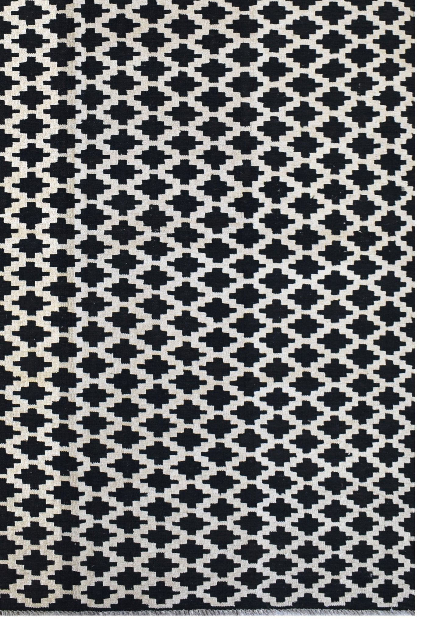 Handmade Afghan Maimana kilim rug featuring a repeating black and white geometric pattern.