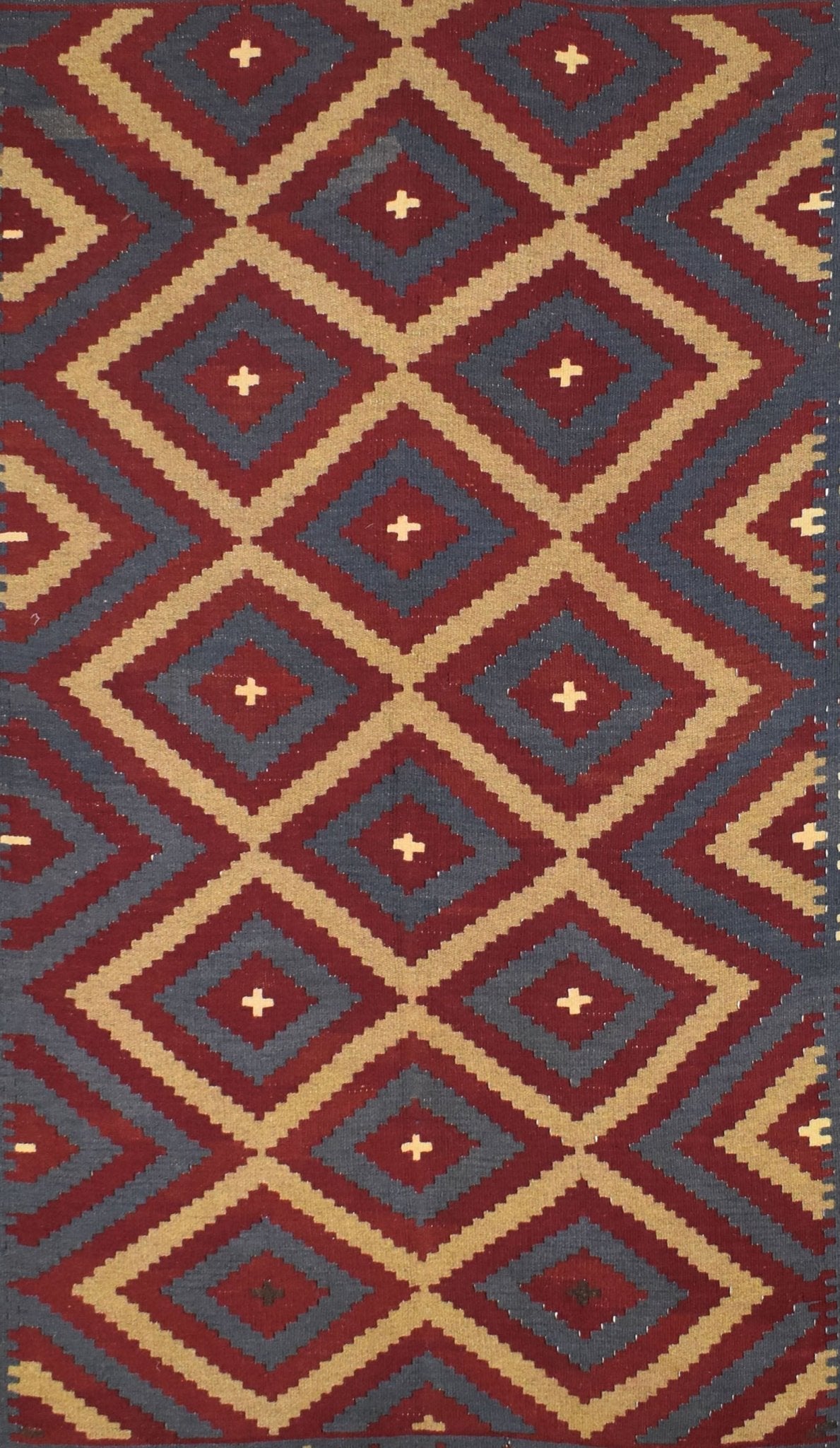 Handmade Afghan Maimana kilim rug featuring a repeating geometric diamond pattern in red and tan.