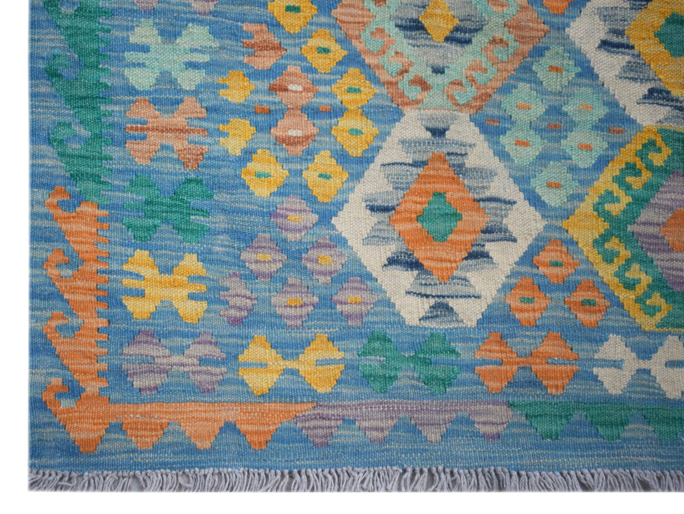 Handwoven Afghan Maimana kilim rug featuring a blue background with colorful geometric patterns.
