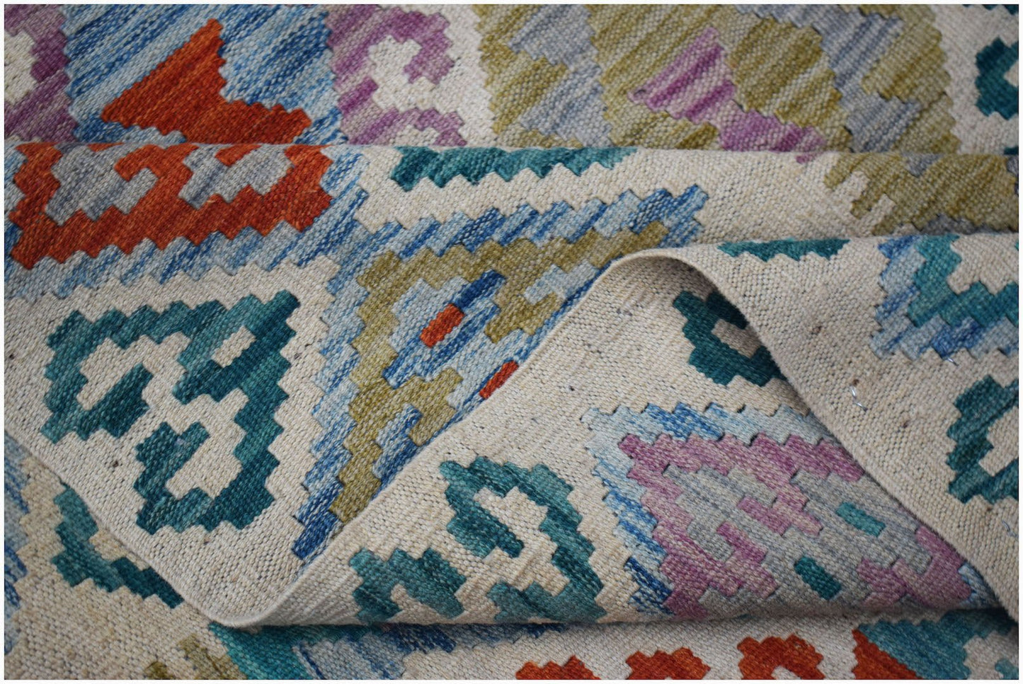 Handwoven Afghan Maimana kilim rug featuring a colorful geometric pattern on a flat wool weave.