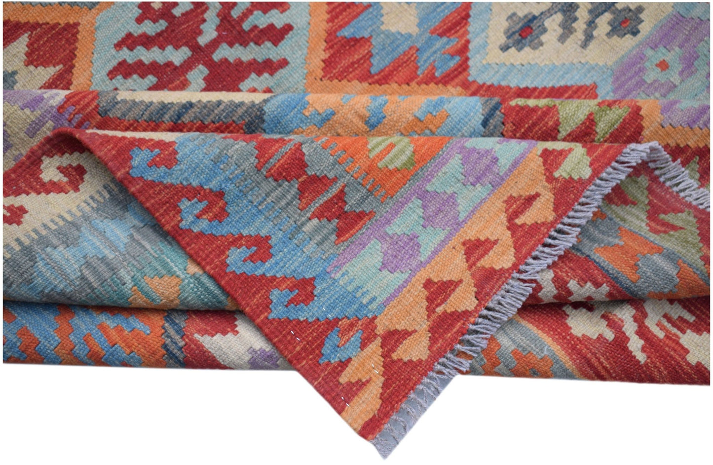A handmade Afghan Maimana kilim rug featuring vibrant geometric patterns in wool.