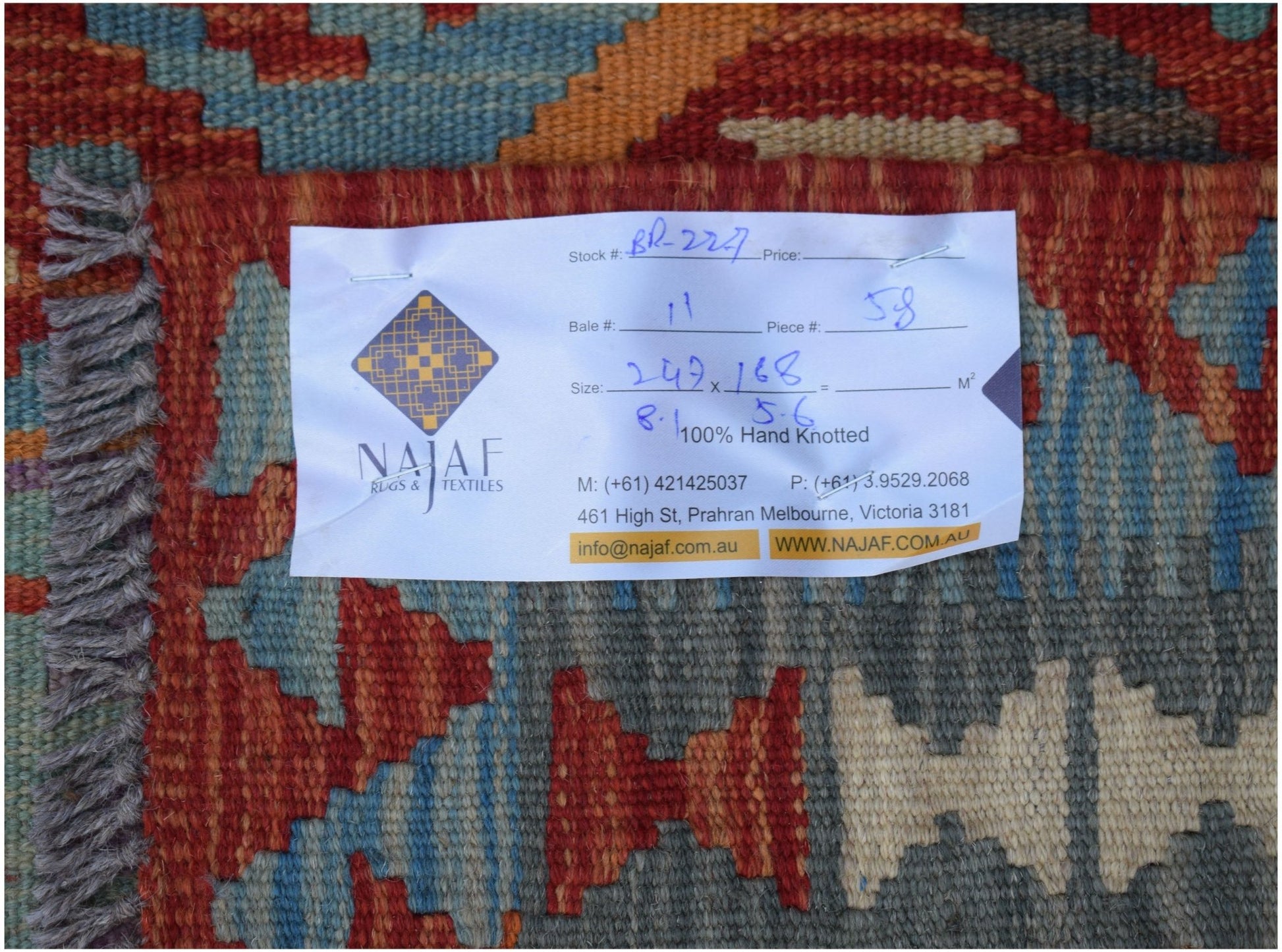 A handwoven Afghan Maimana Kilim featuring a geometric pattern in rich red, blue, and grey tones.