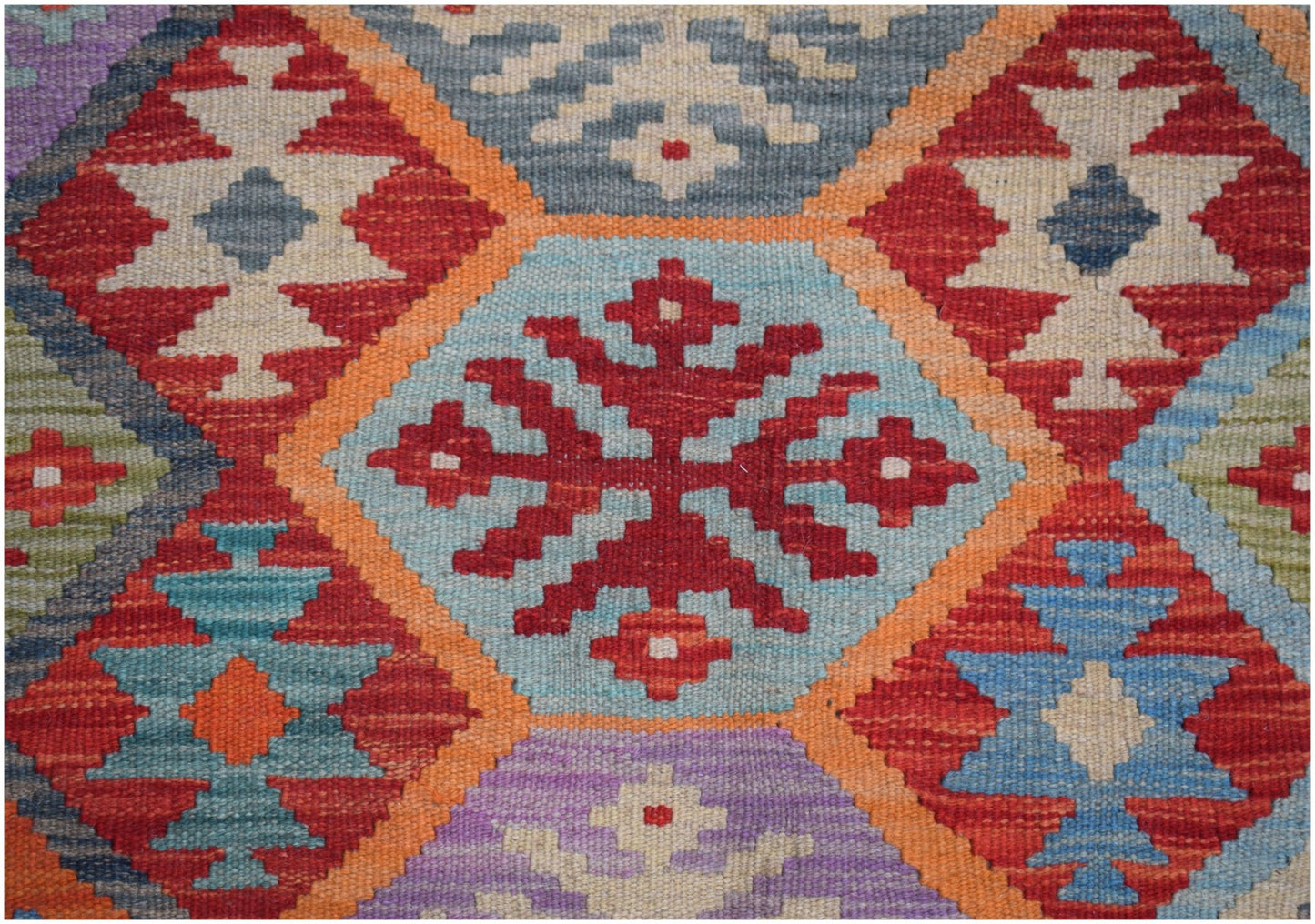Handwoven Afghan Maimana kilim featuring a vibrant geometric pattern in wool.