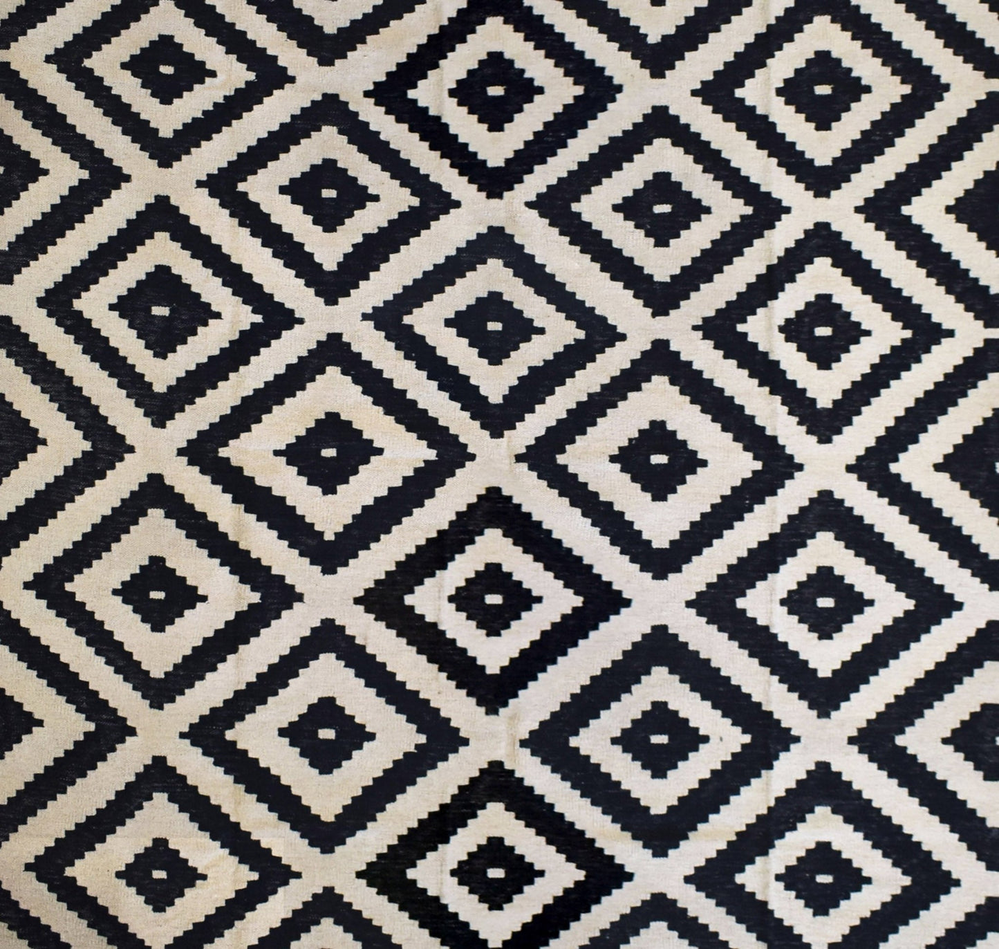Handmade Afghan Maimana kilim rug featuring a repeating black and cream geometric diamond pattern.