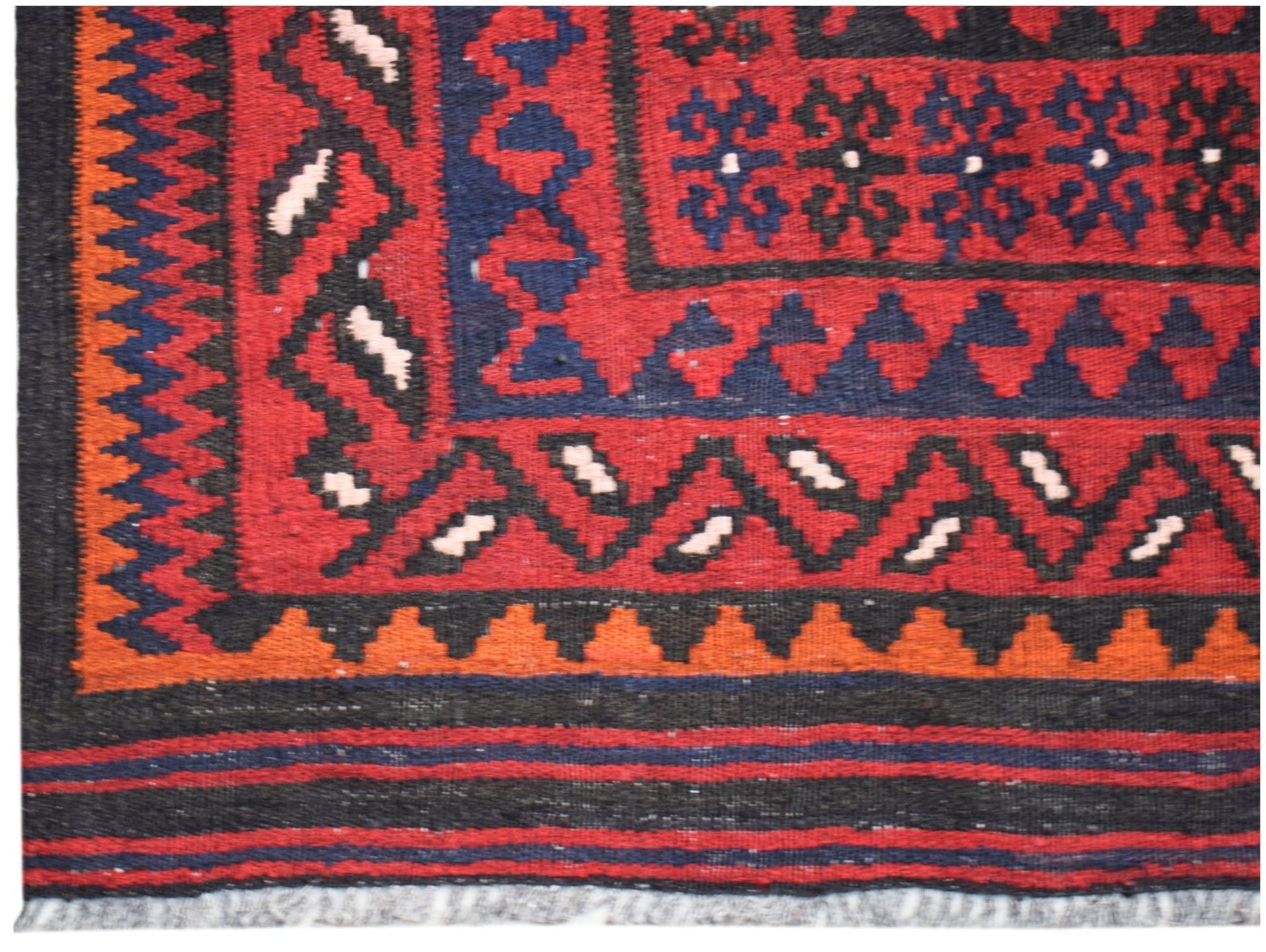 A handmade Afghan Maimana kilim featuring geometric patterns in red, blue, black, and orange.
