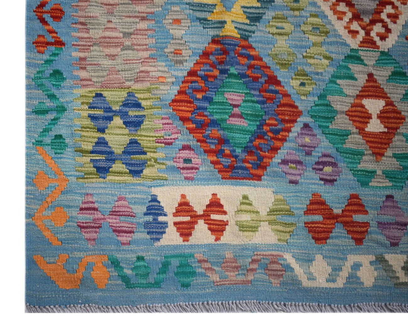 Handwoven Afghan Maimana Kilim rug featuring a vibrant geometric pattern on a blue background.