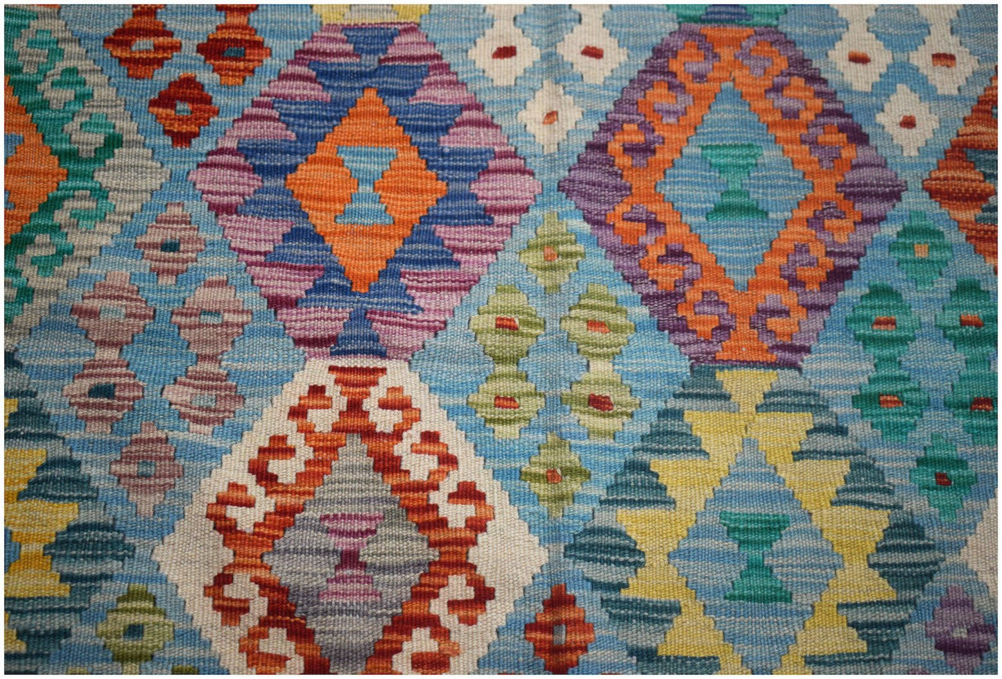 Handwoven Afghan Maimana kilim featuring a vibrant geometric diamond pattern in wool.