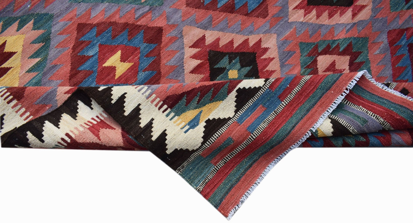 Handwoven Afghan Maimana kilim featuring a geometric pattern in vibrant red, blue, and yellow.