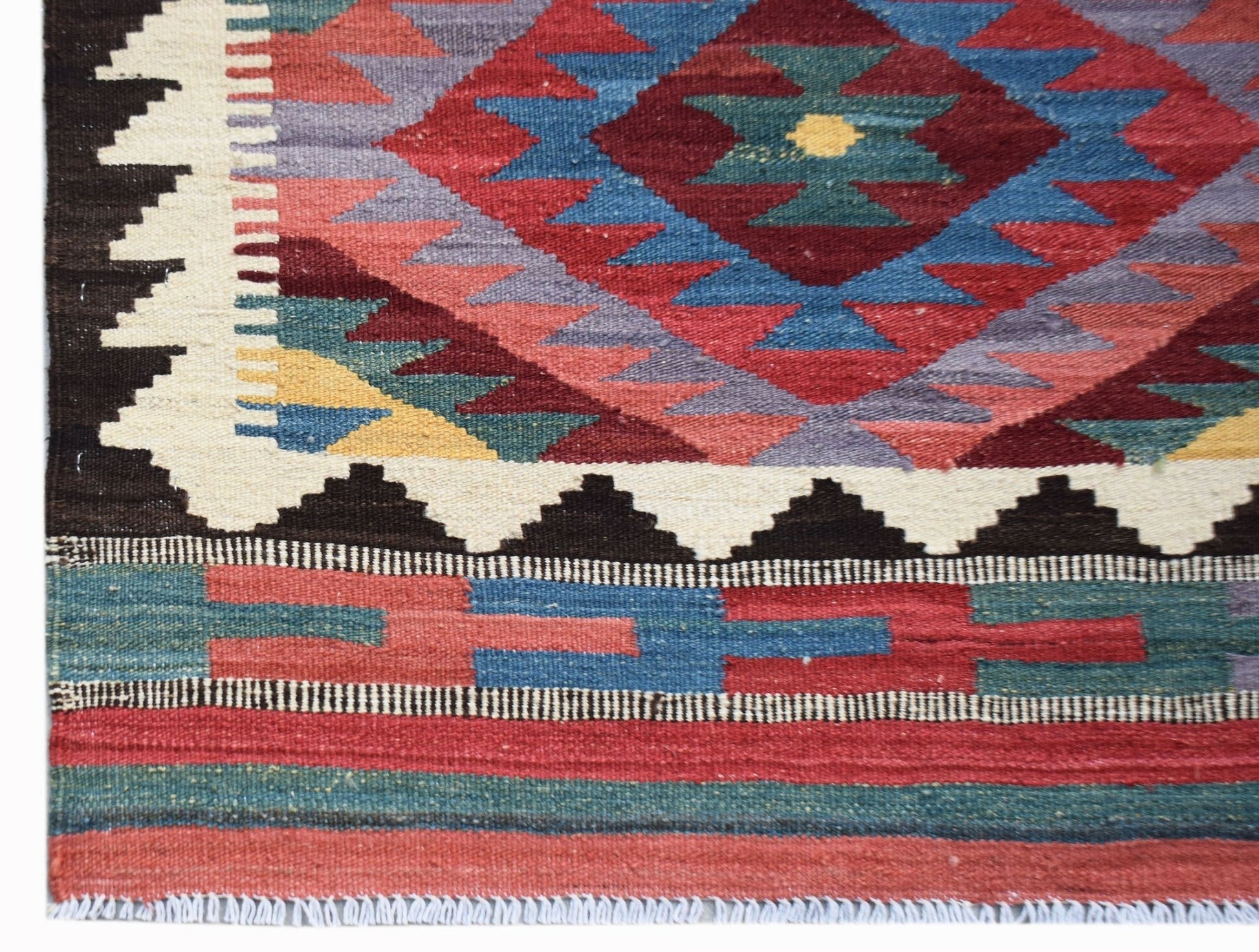 Handwoven Afghan Maimana kilim featuring a geometric pattern in red, blue, and cream wool.