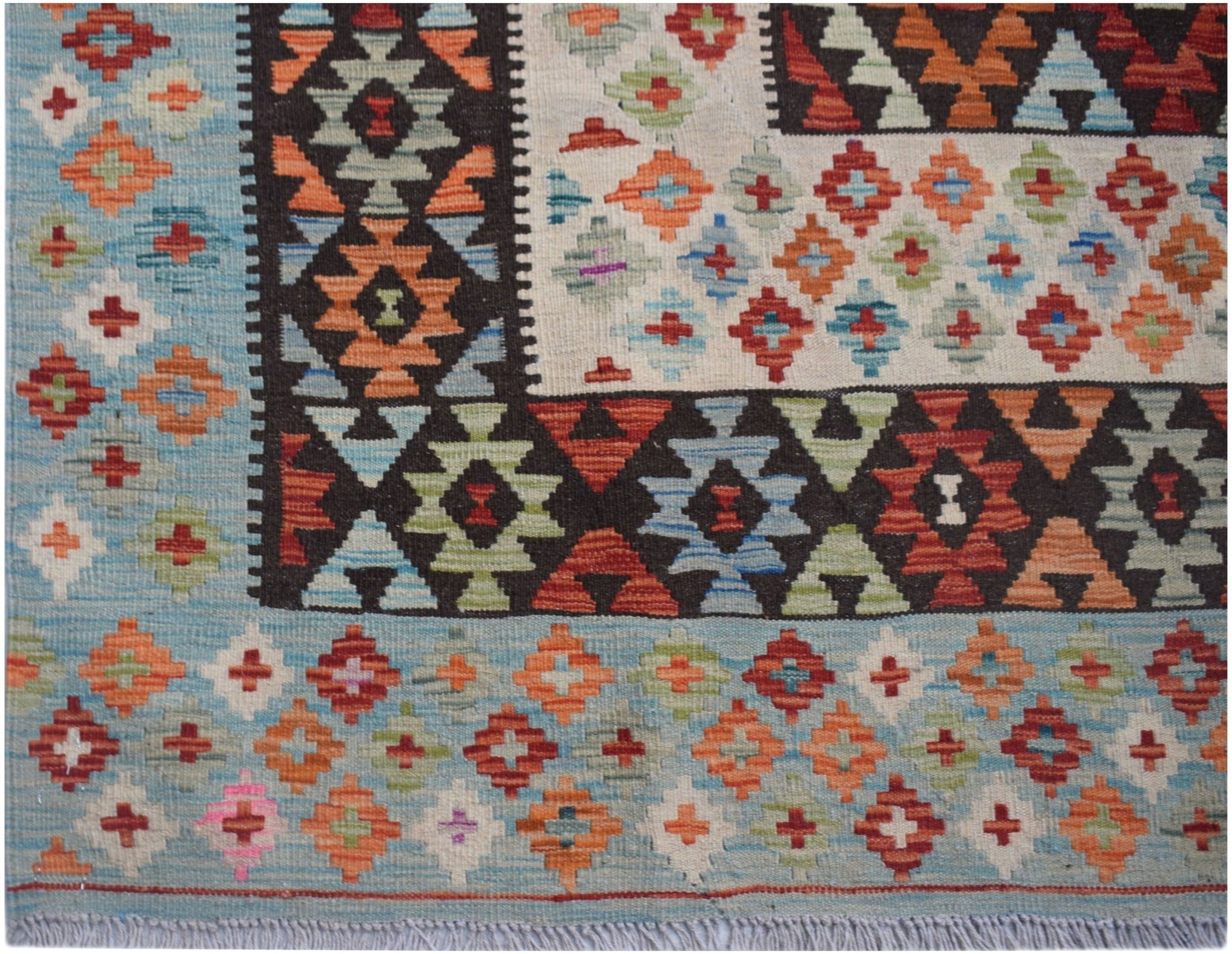 Handwoven Afghan Maimana kilim rug featuring a geometric pattern in blue, orange, and red wool.