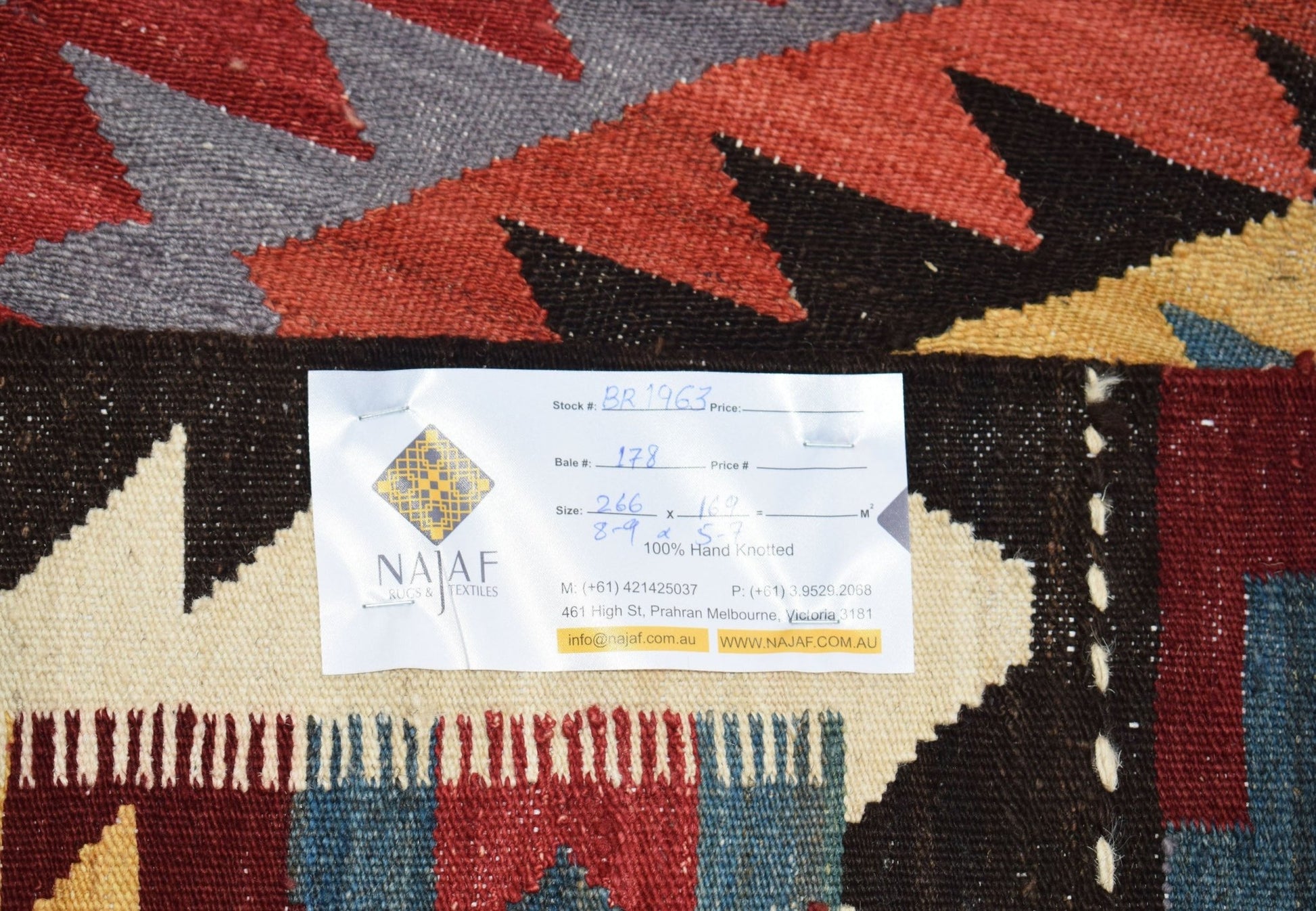 A handmade Afghan Maimana kilim featuring a geometric pattern in red, blue, and yellow tones.